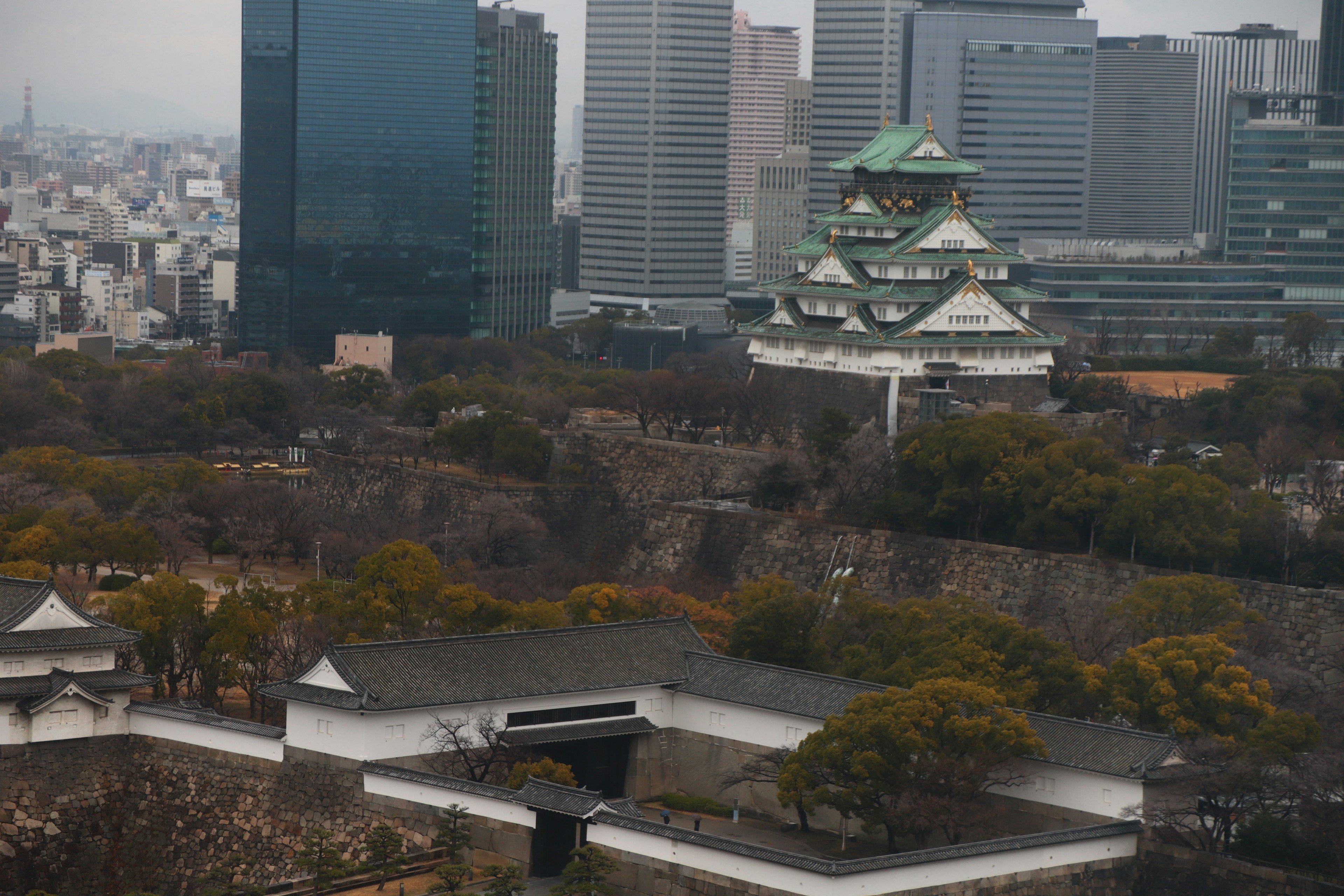 Pemandangan Kastil Osaka yang kontras dengan gedung pencakar langit modern