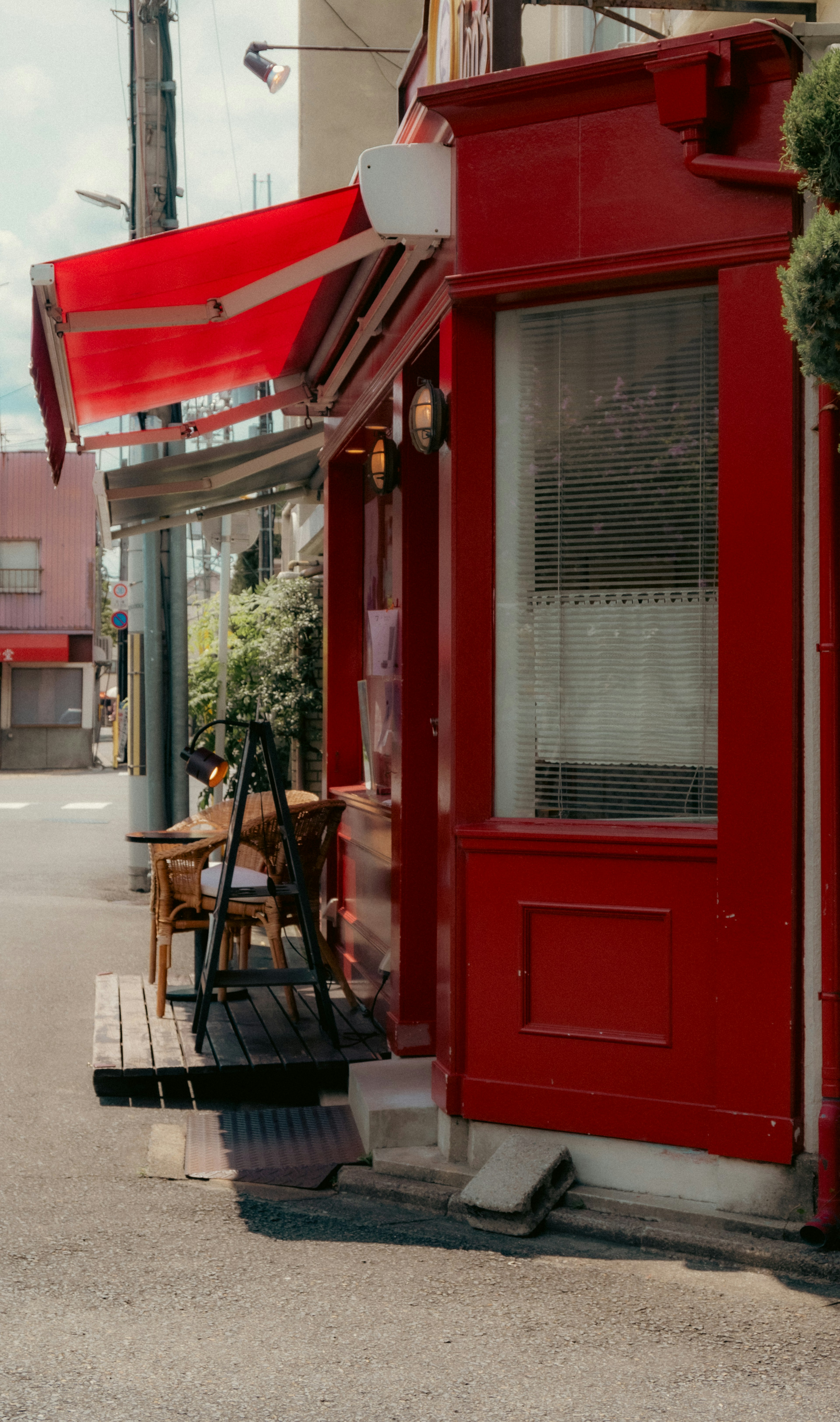 Pintu kafe merah dengan tempat duduk luar