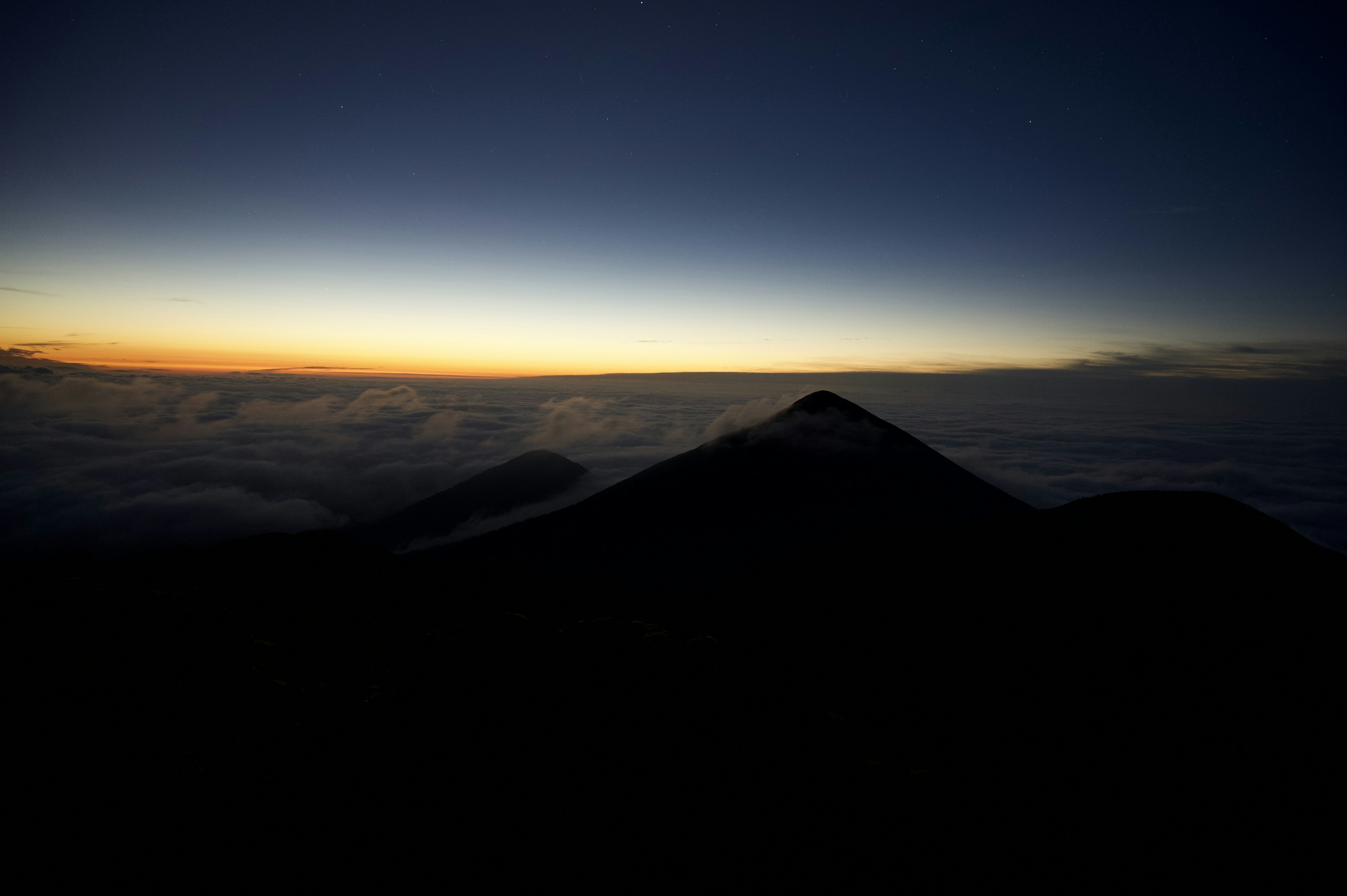 Silhouette of a mountain at dawn with a gradient sky