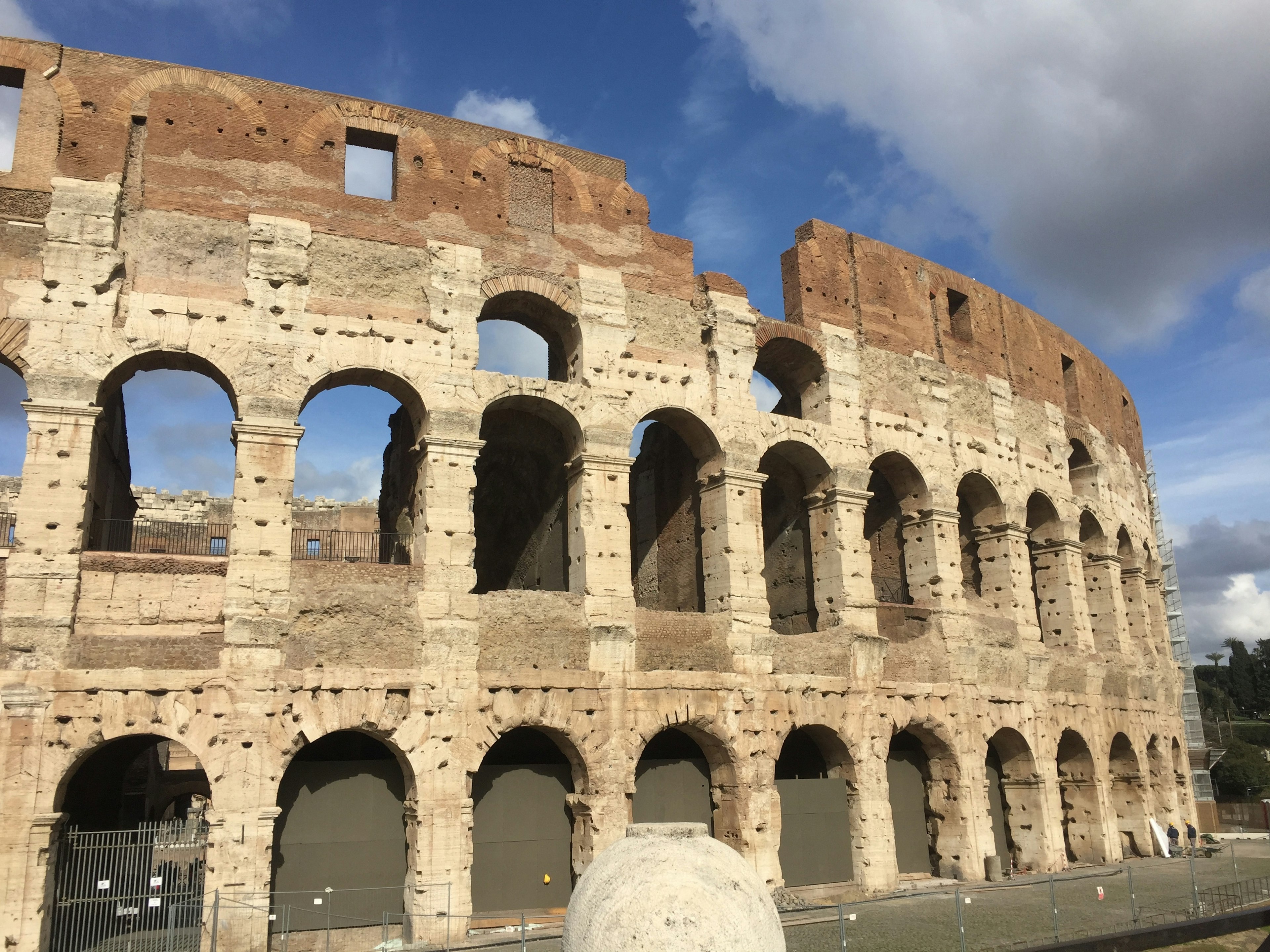 Tampilan luar Colosseum di Roma dengan bagian yang rusak dan lengkungan