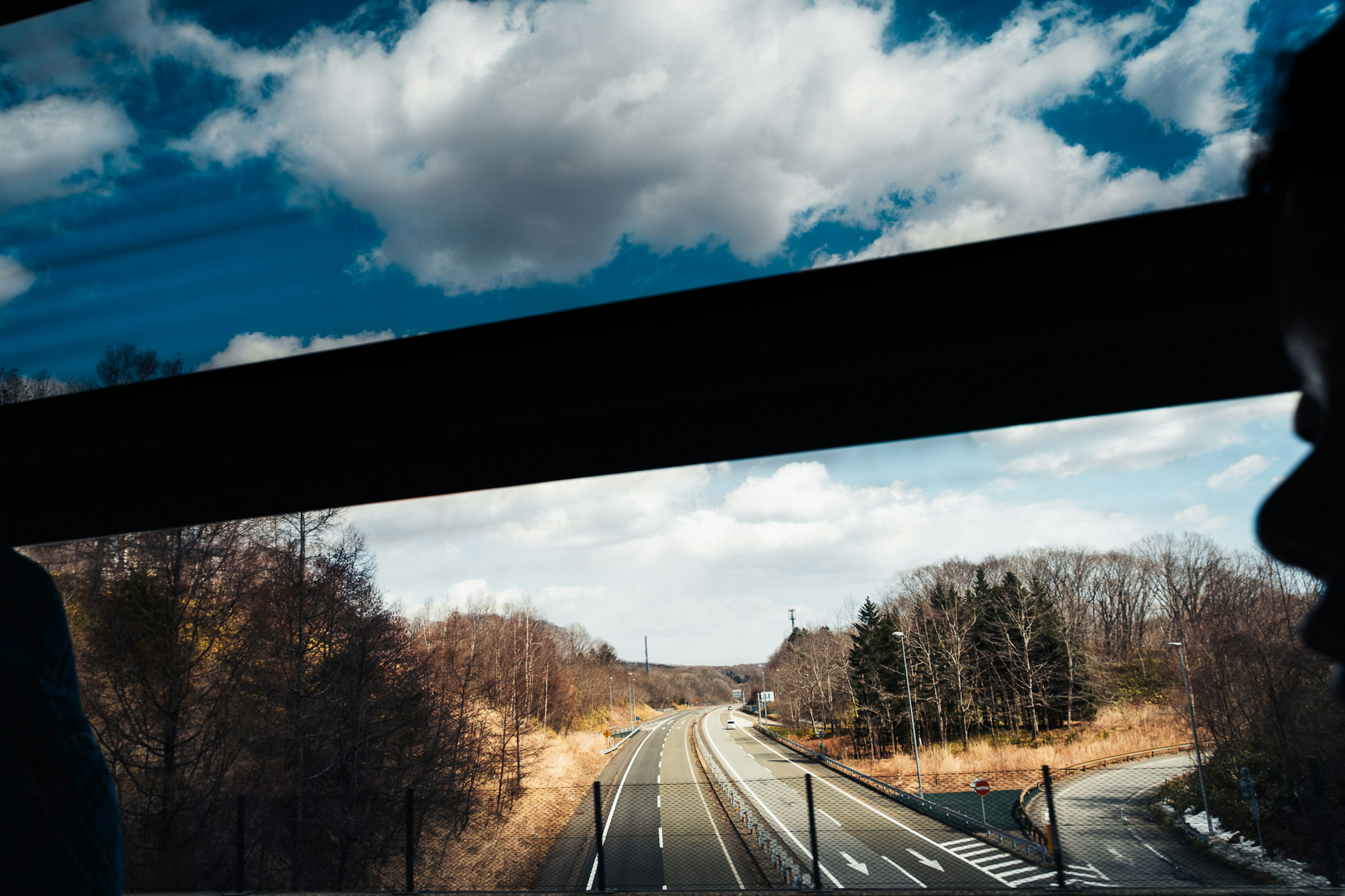 窓から見える風景と青い空、雲、道路、冬の景色