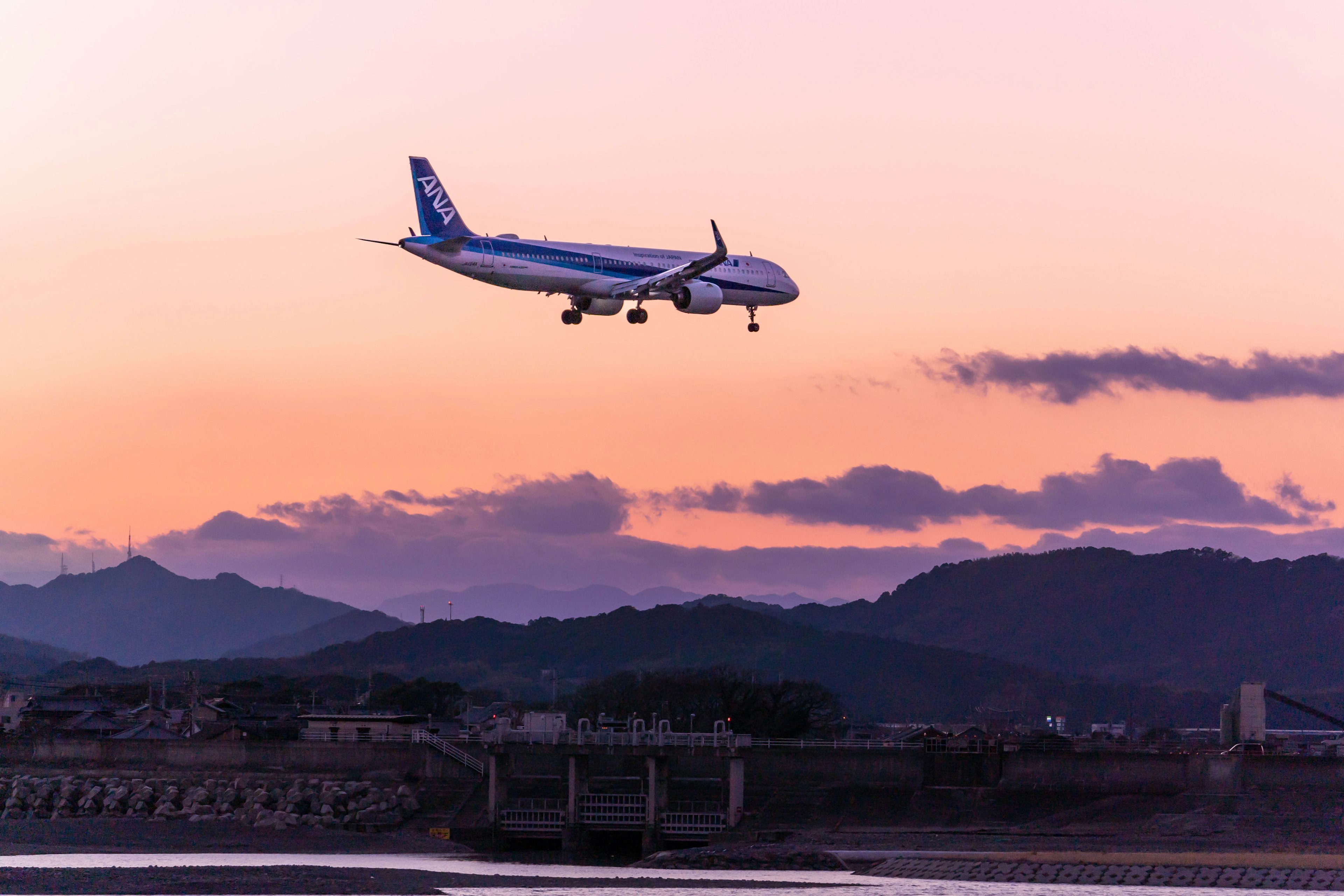 Ein Flugzeug, das in einem Sonnenuntergangshimmel landet