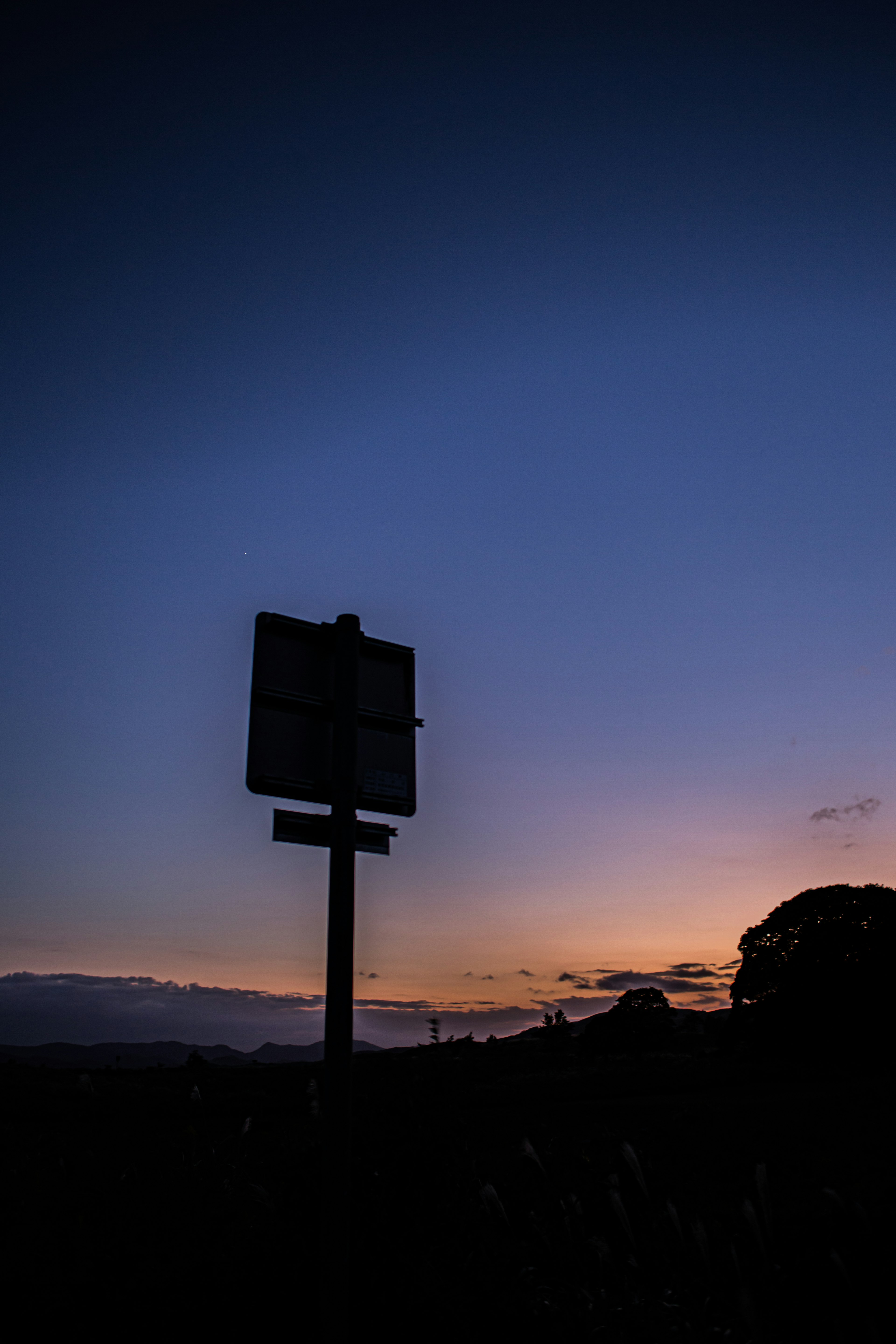 Silhouette eines Schildes vor einem Sonnenuntergangshimmel