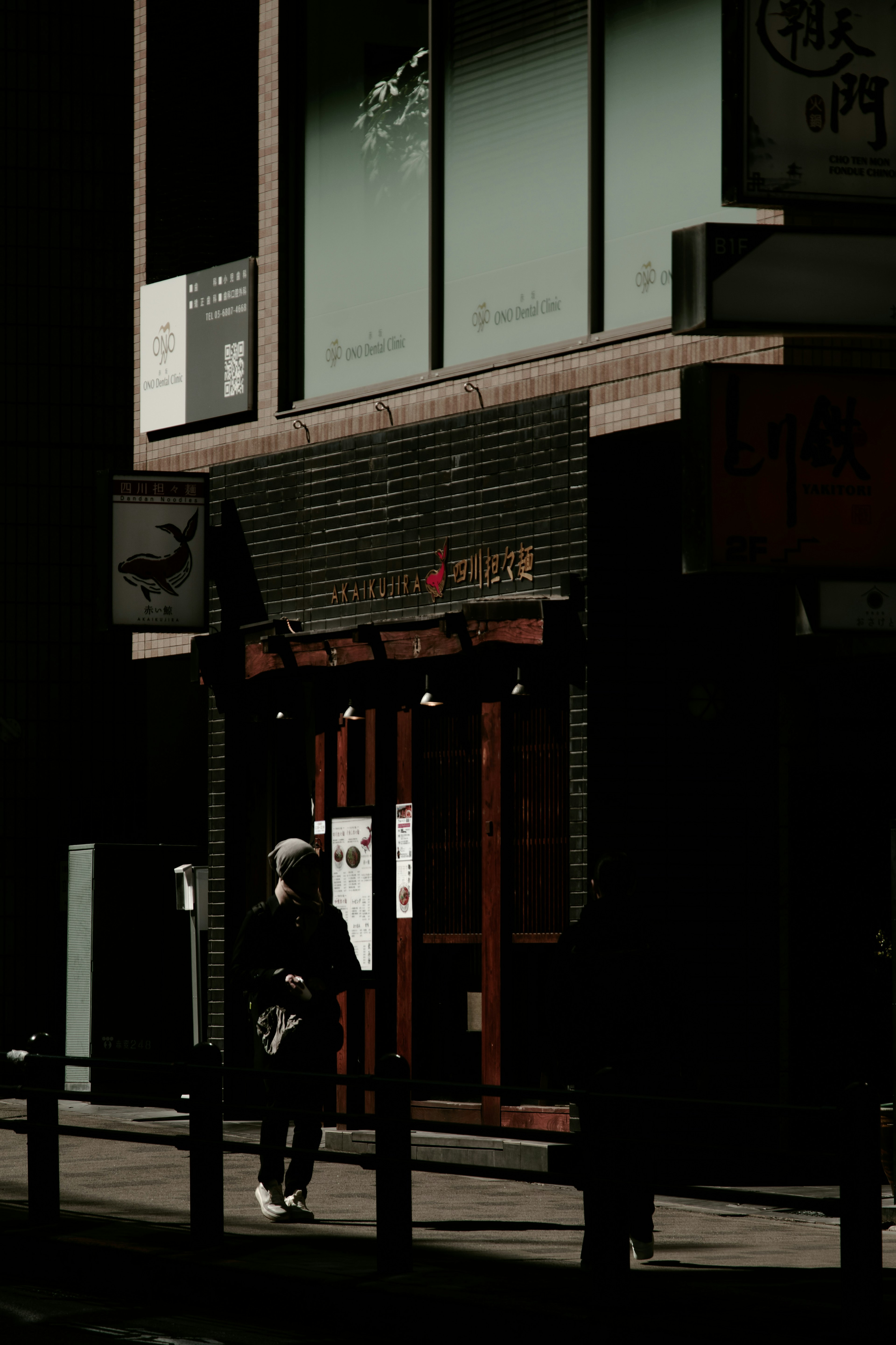 Exterior of a restaurant with a wooden door on a dark street