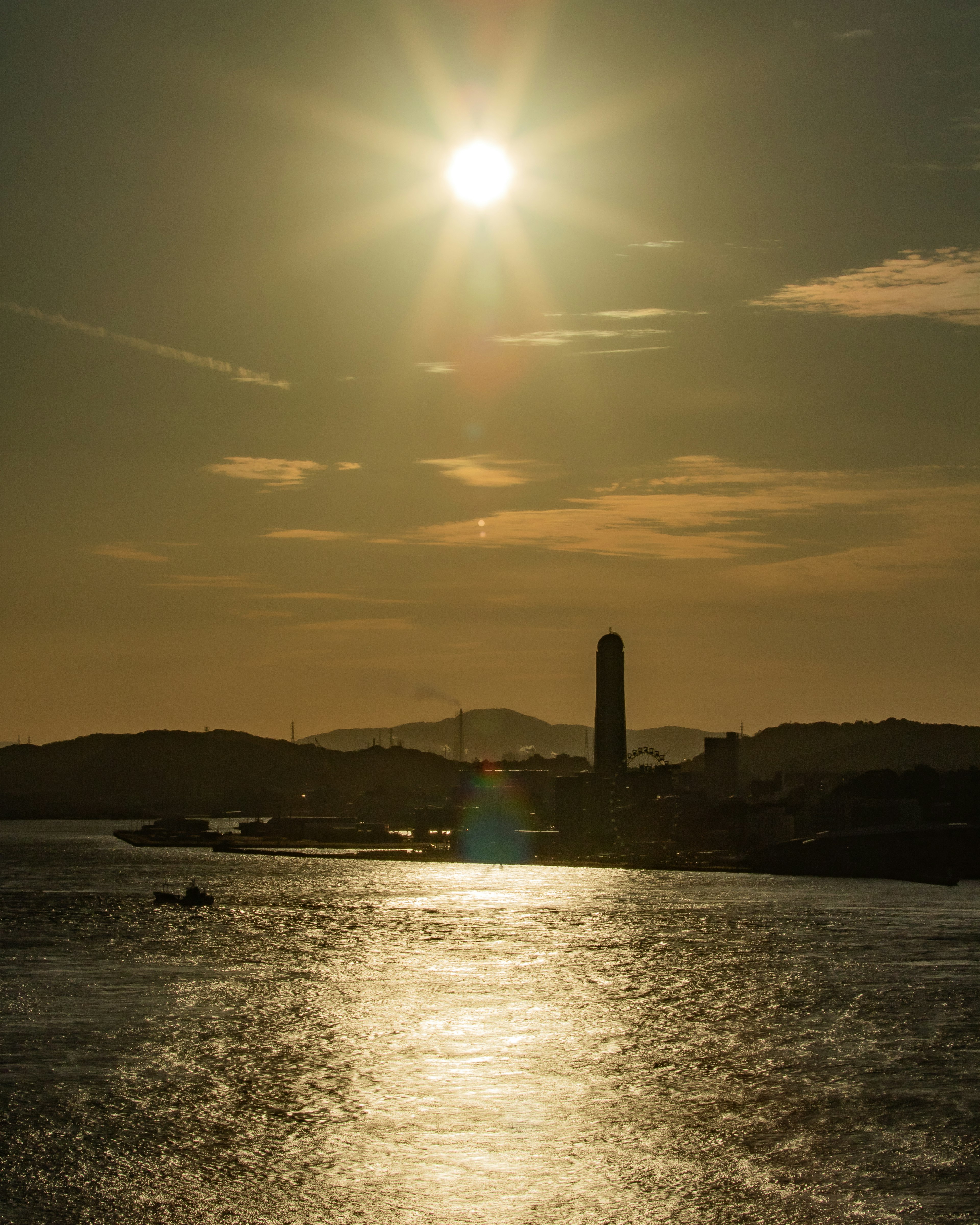 Coucher de soleil se reflétant sur l'eau avec une tour en silhouette