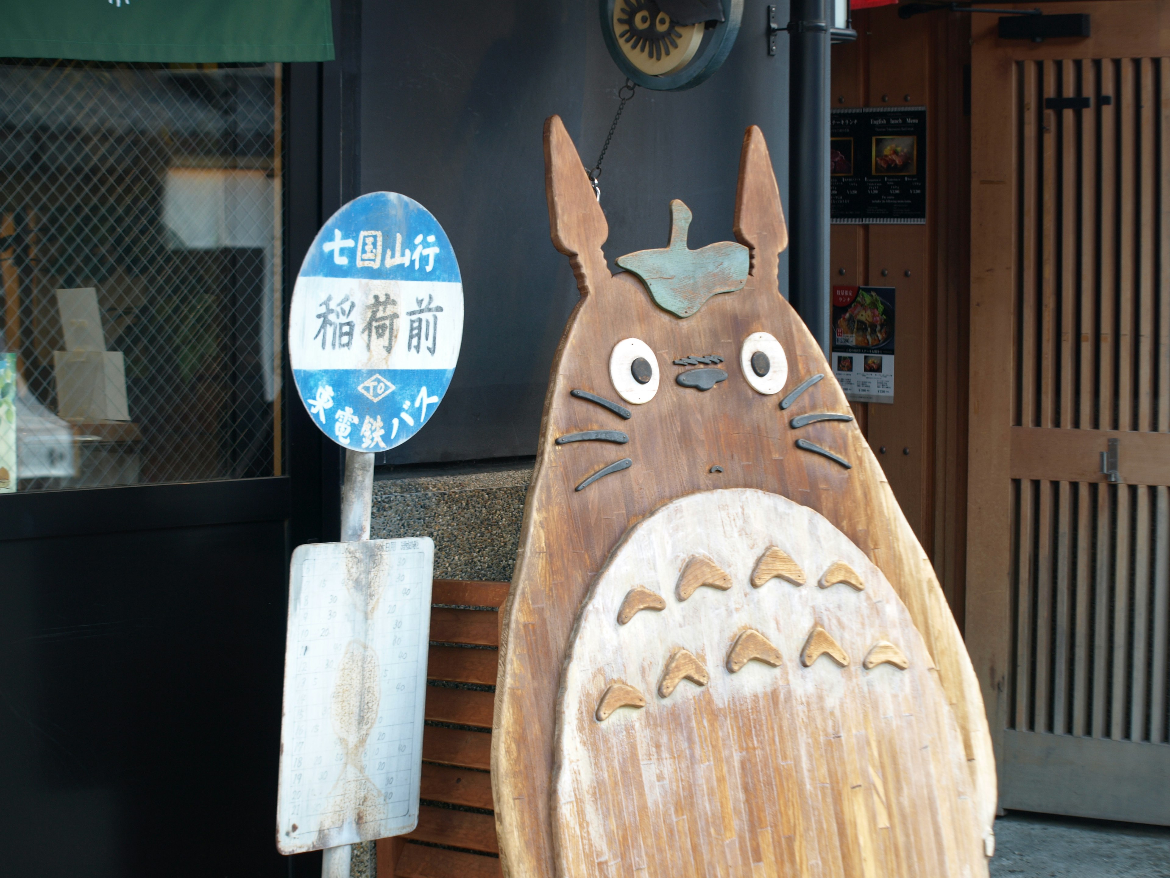 Cartel de madera de Totoro en la entrada de una tienda