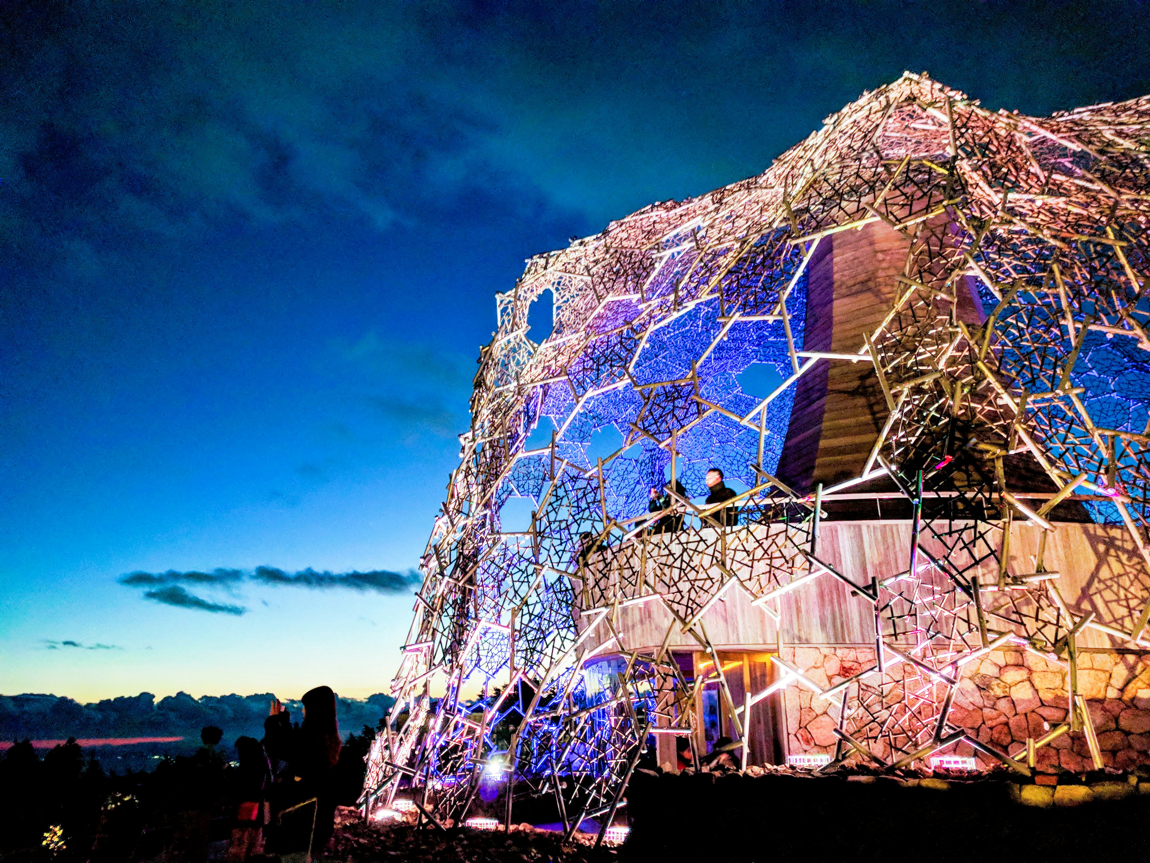 Estructura única iluminada por la noche con un hermoso cielo de fondo