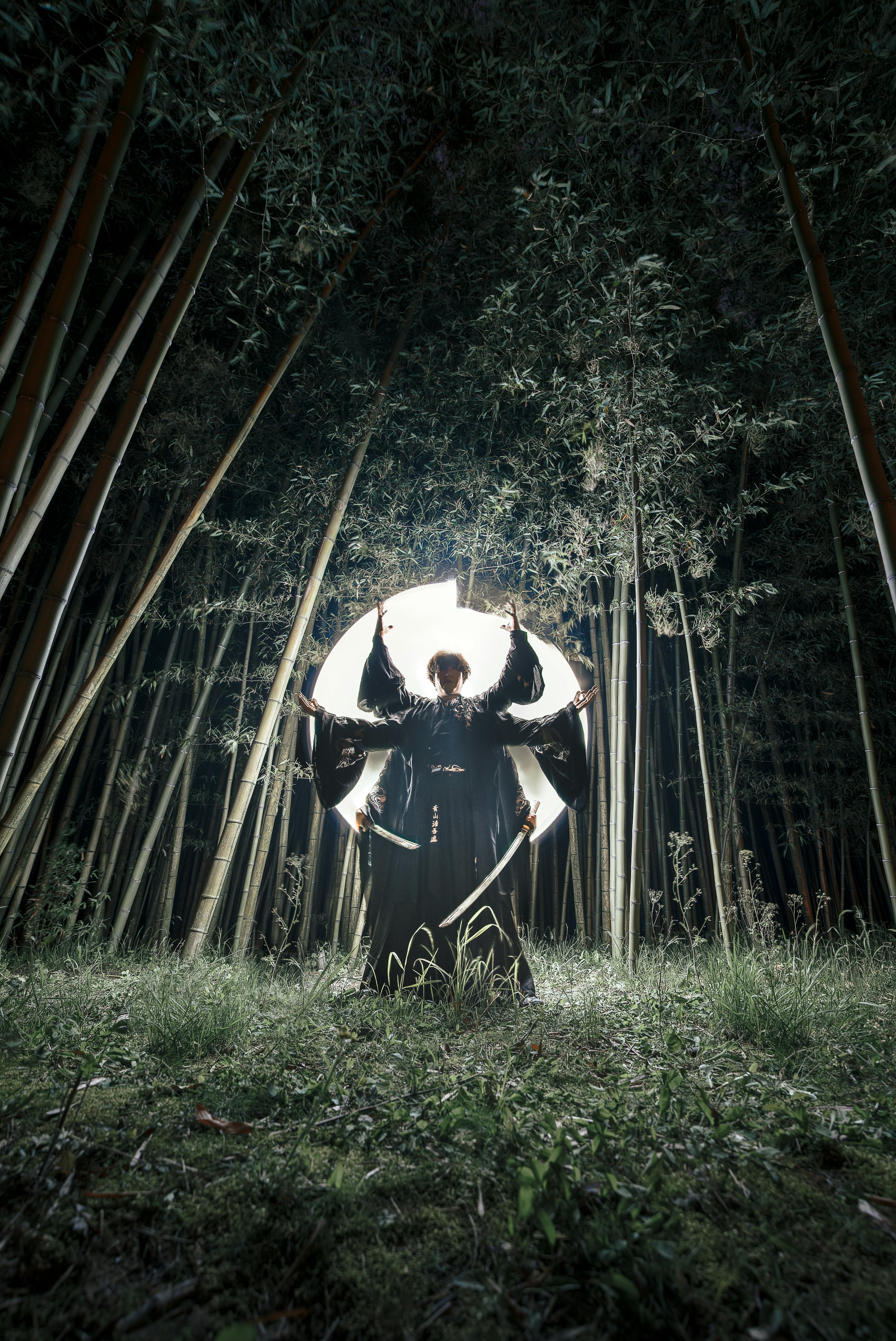 Une silhouette tenant un parapluie dans une forêt de bambous