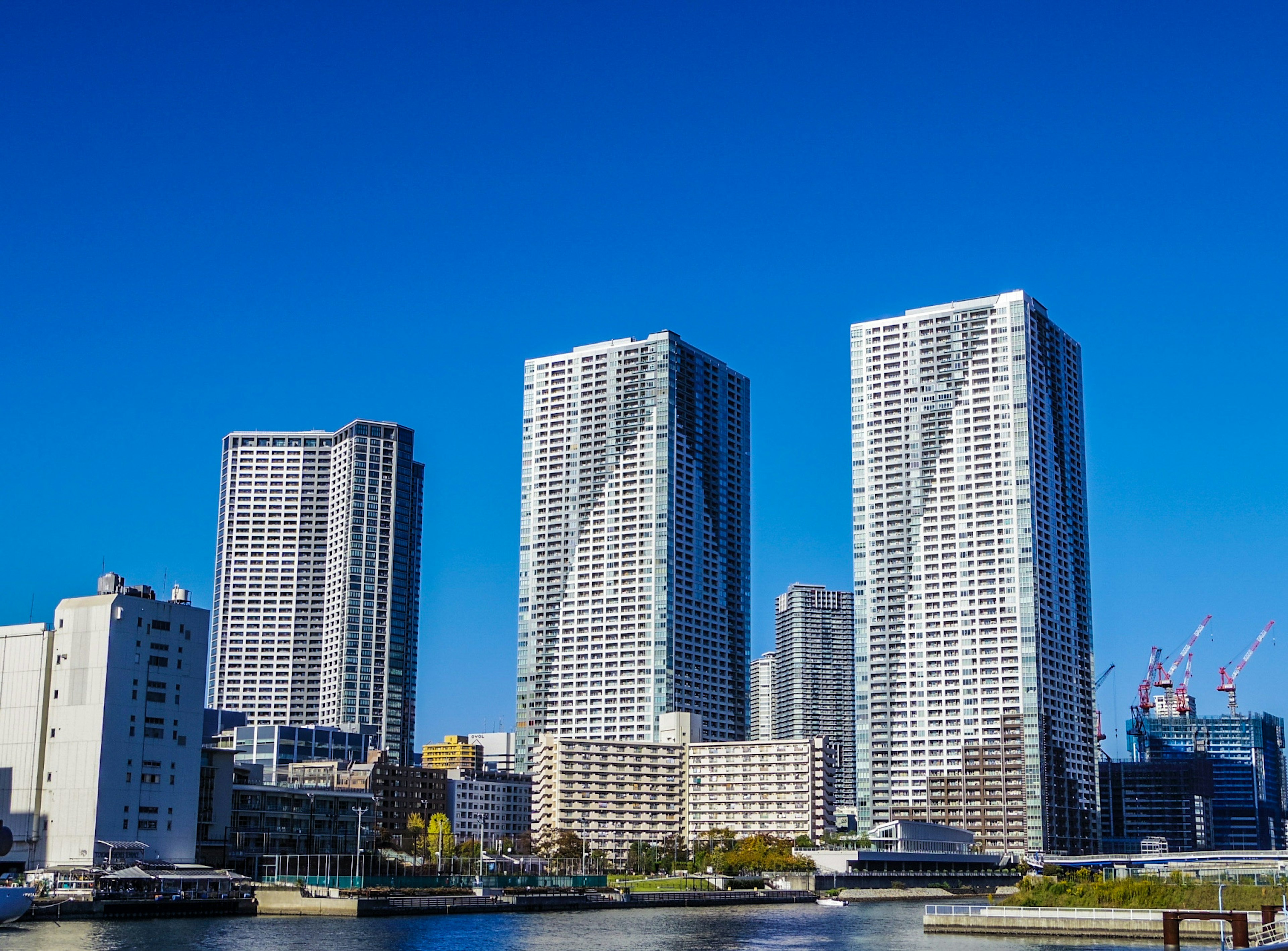 Skyline of modern skyscrapers by the waterfront under a clear blue sky