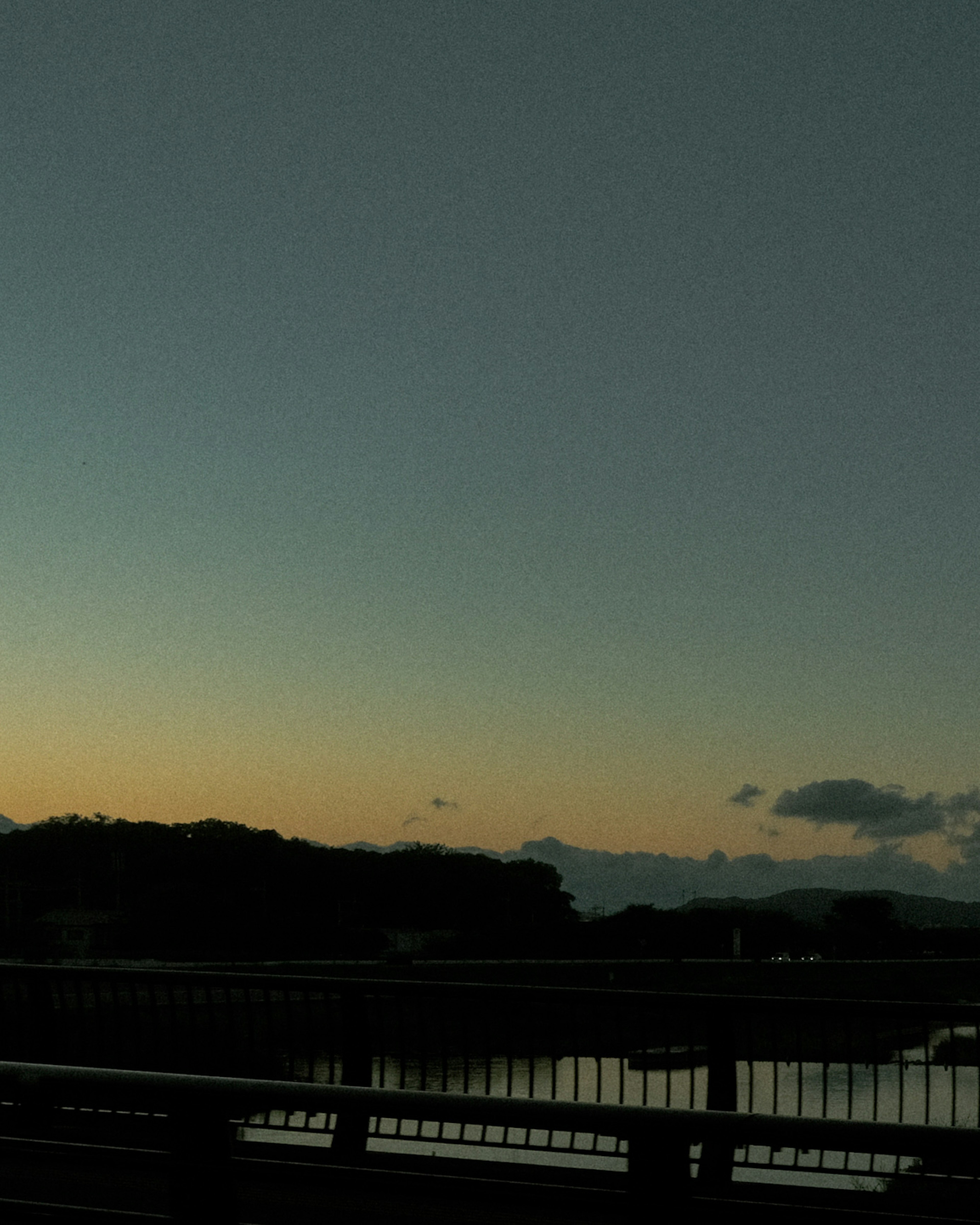 Vue calme du coucher de soleil depuis un pont avec des reflets sur l'eau