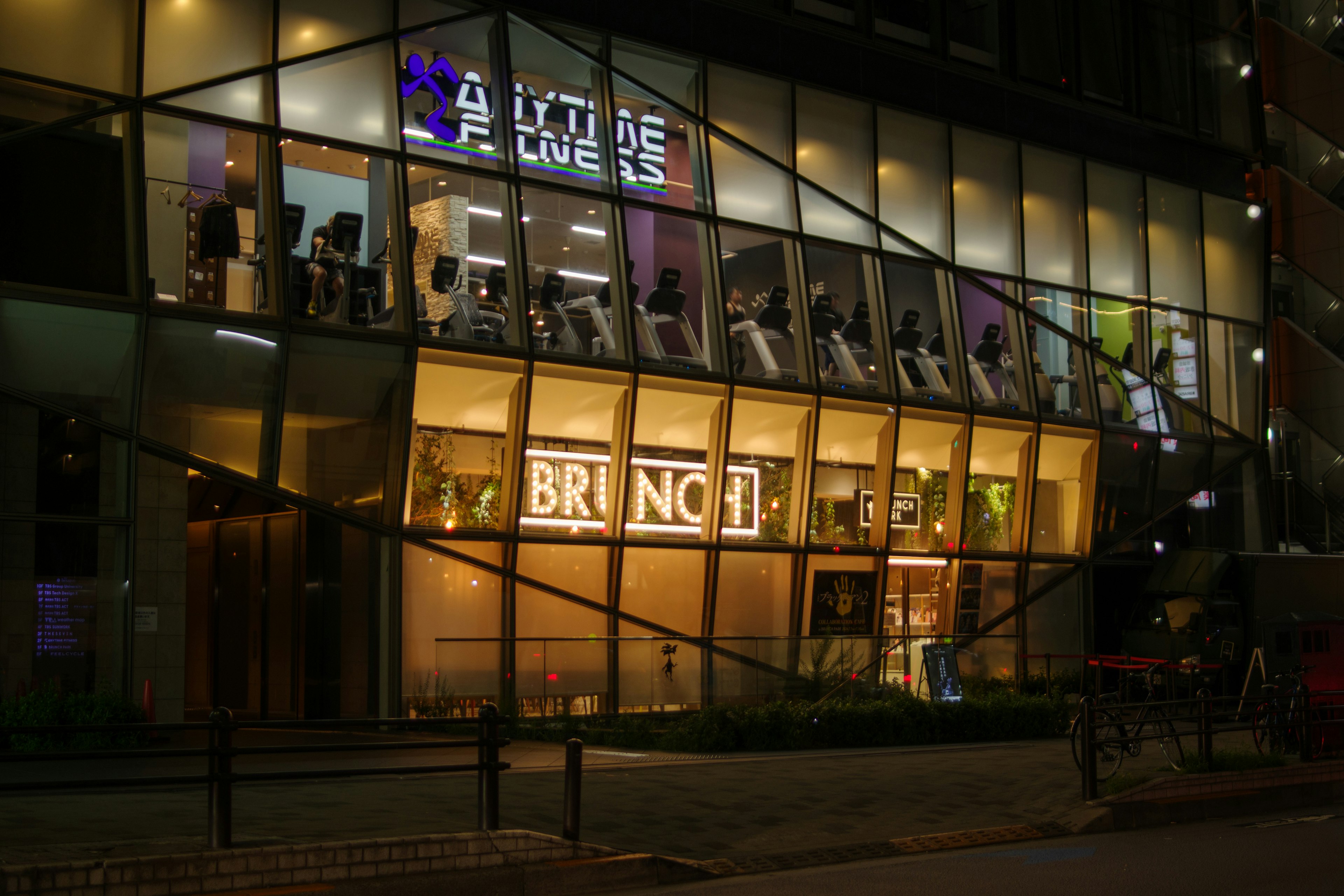 Exterior de un edificio moderno con ventanas brillantes y un letrero de BRUNCH destacado