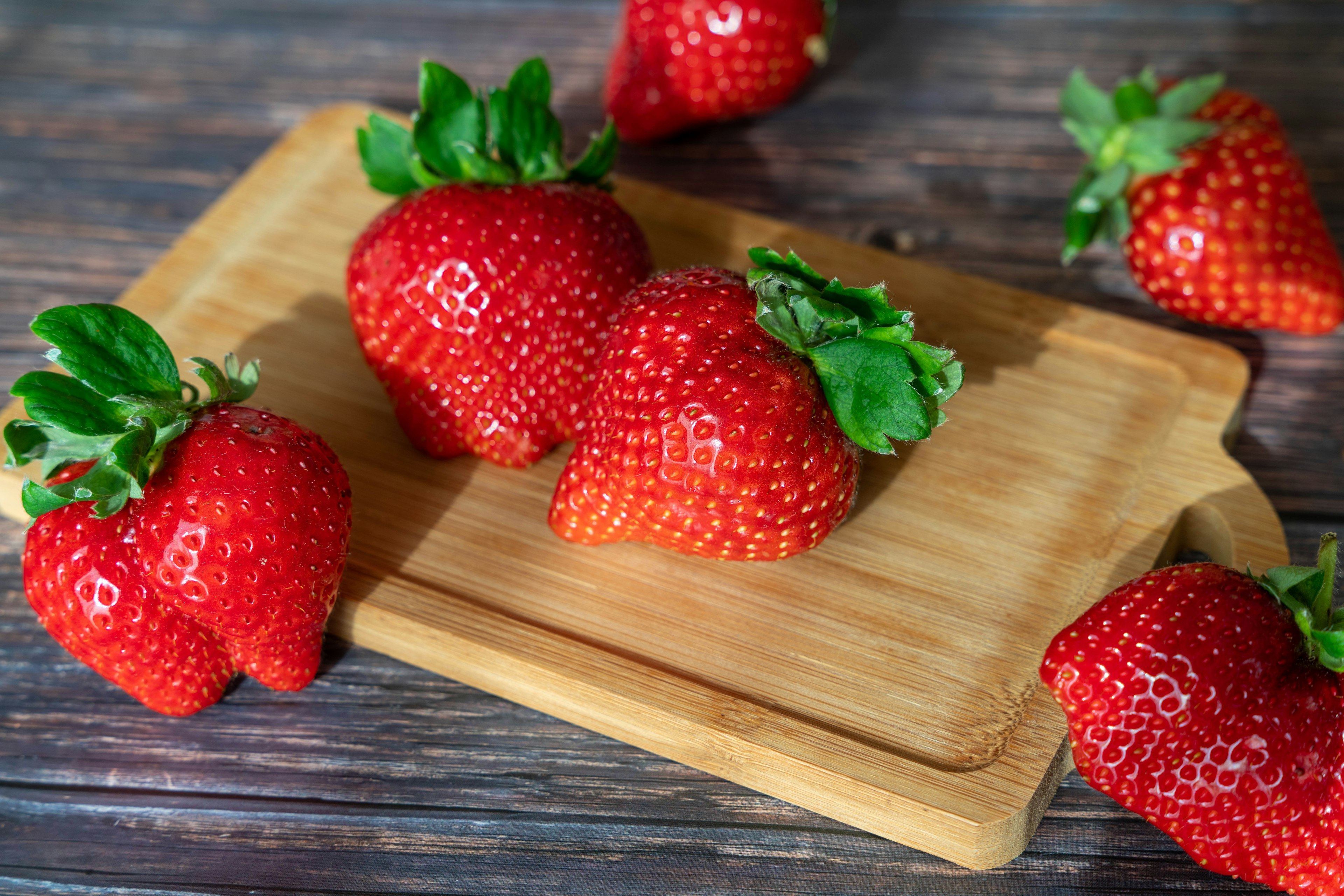 Fraises fraîches disposées sur une planche à découper en bois