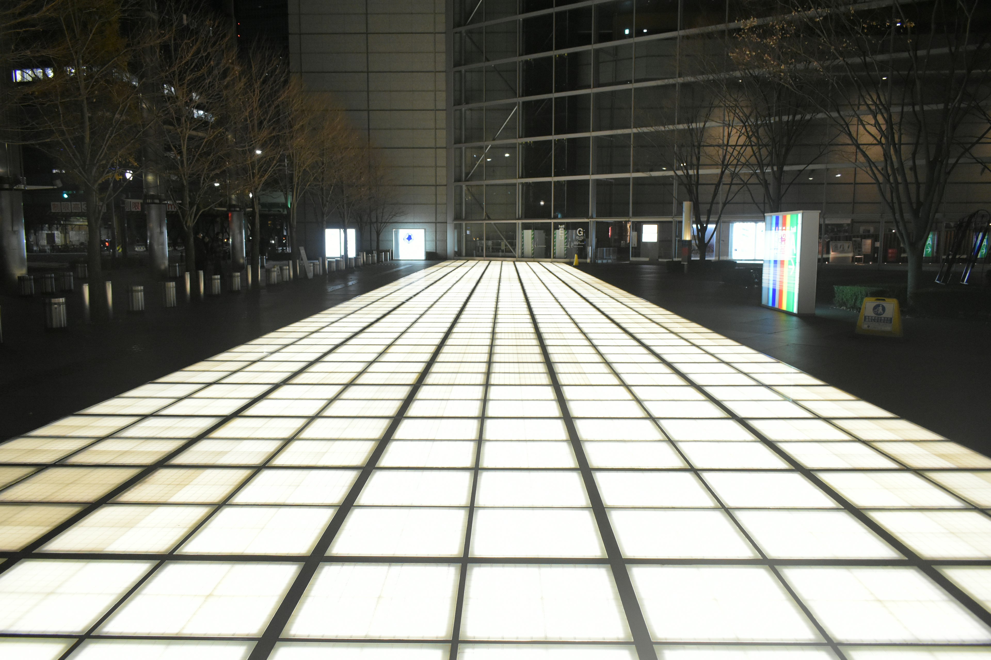 Illuminated tiled pathway in an urban setting at night