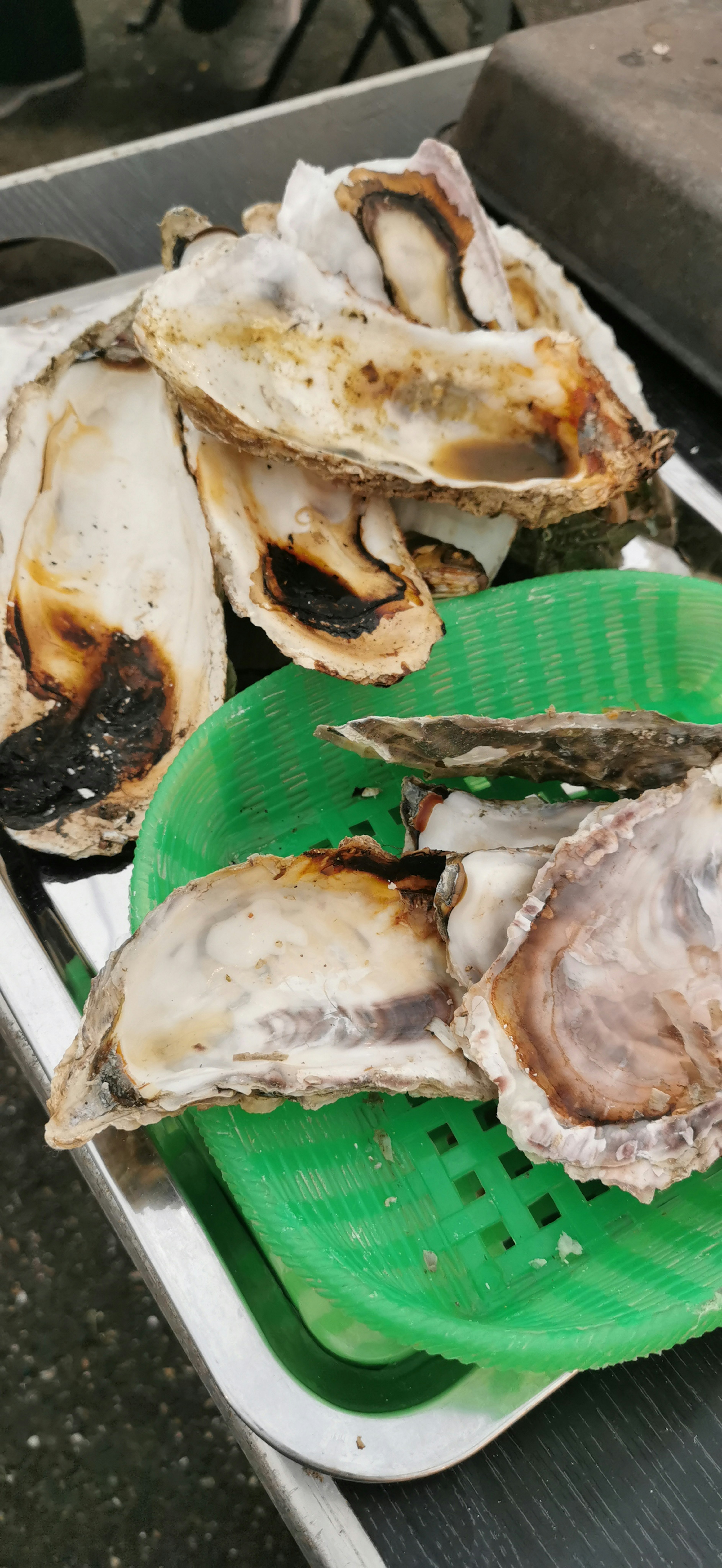 A display of grilled oysters on a green plate