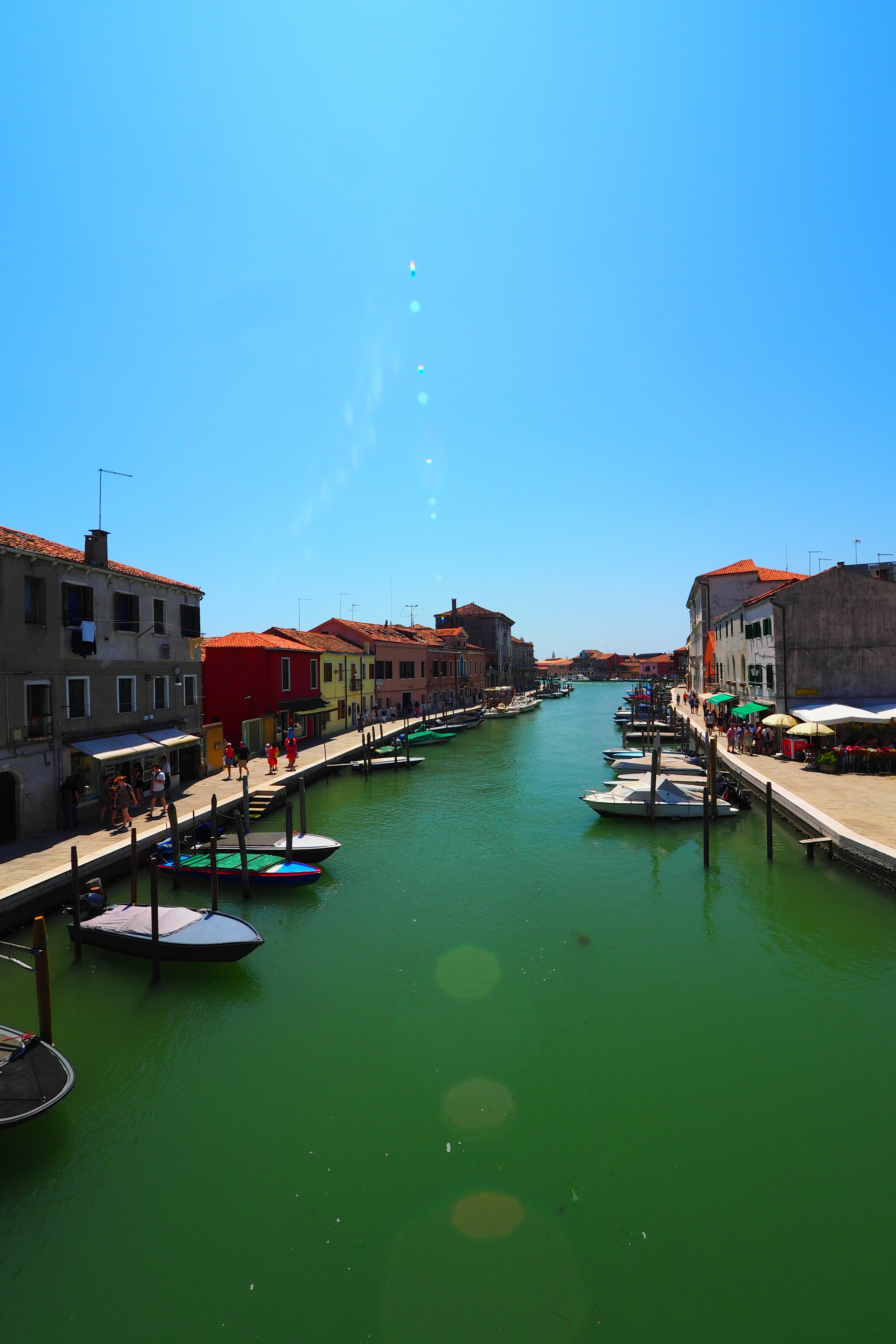 Edificios coloridos y barcos a lo largo de un canal sereno