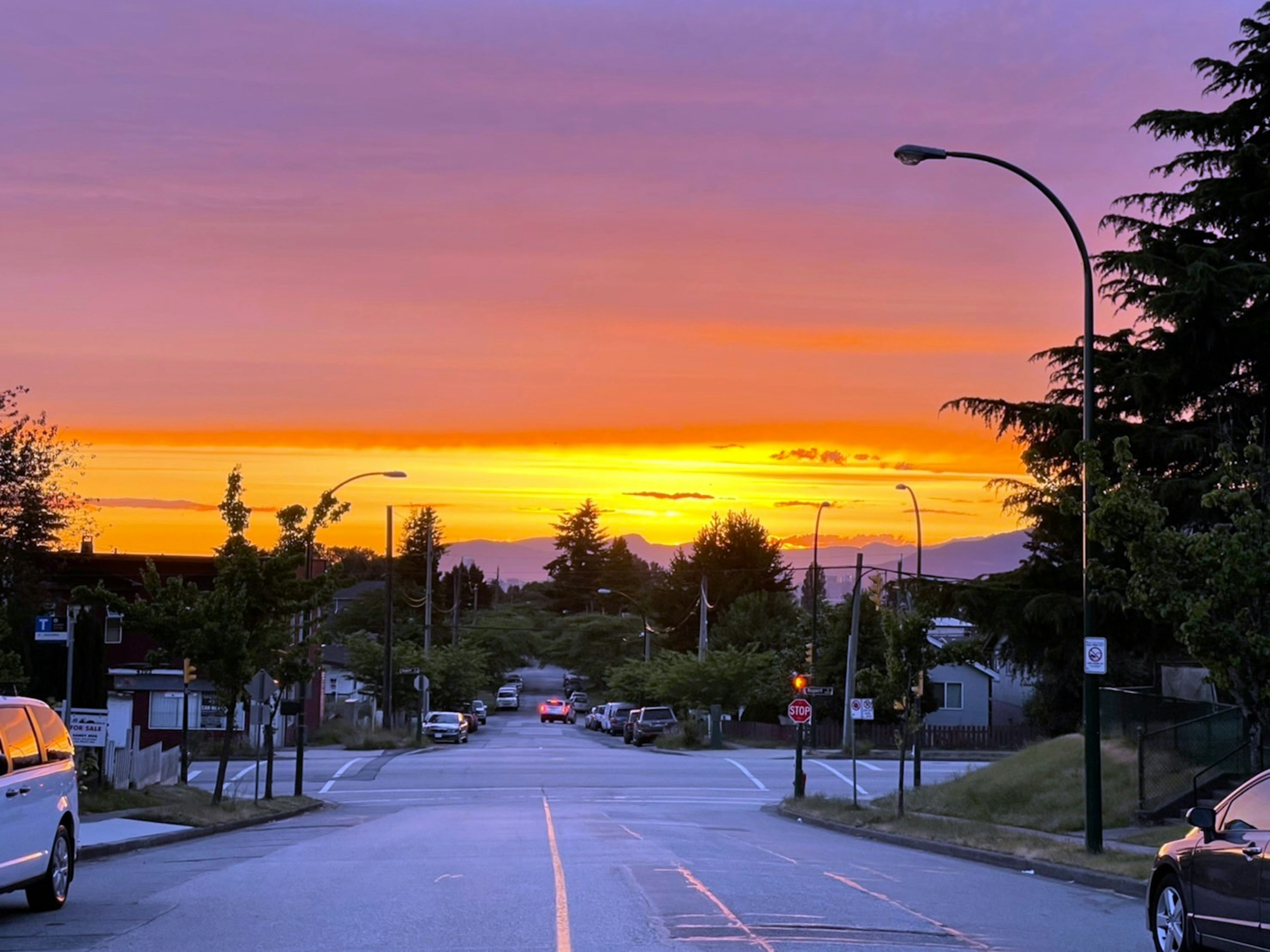 Bellissimo tramonto su una strada tranquilla con auto parcheggiate