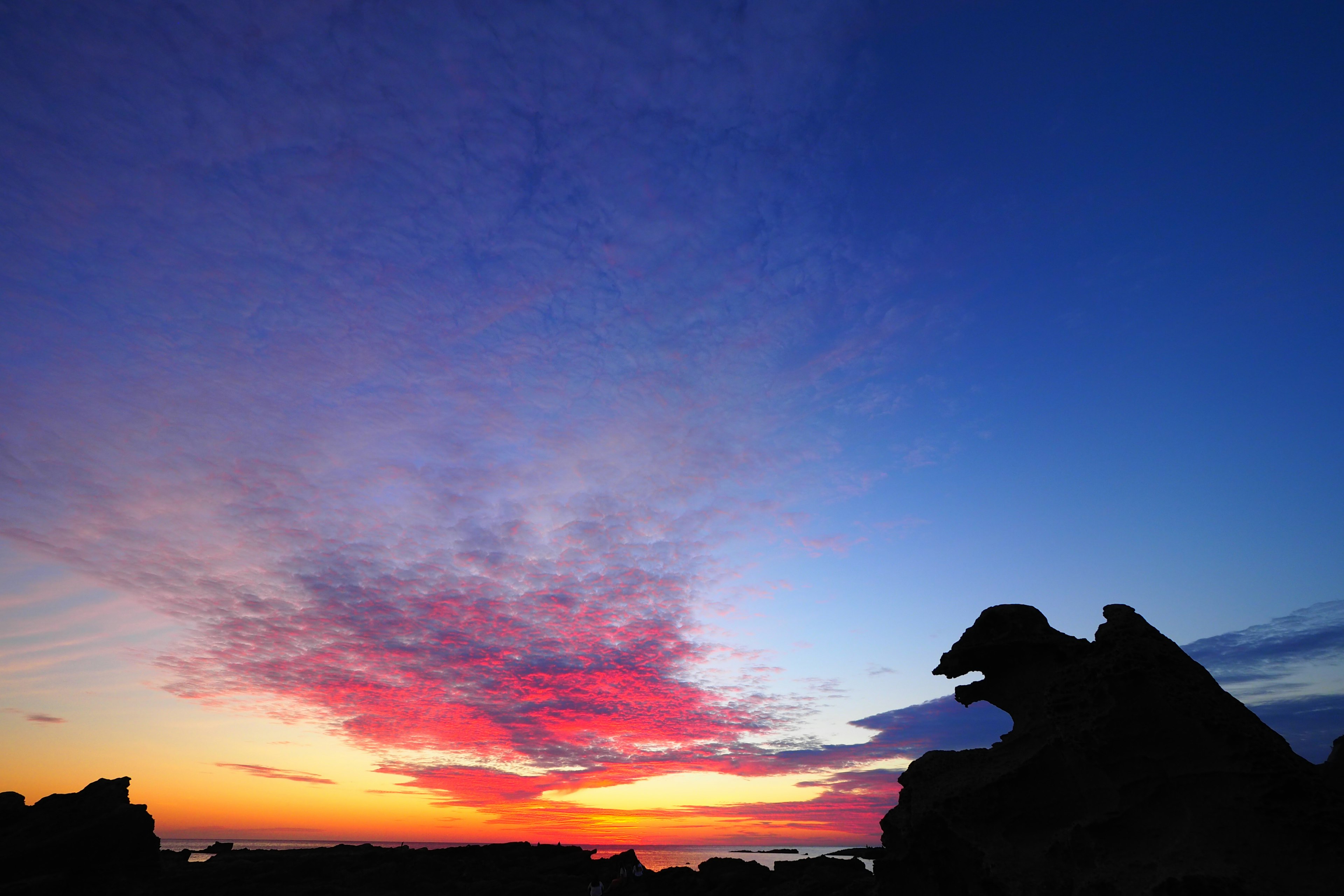 Un tramonto mozzafiato con colori vivaci e silhouette di rocce