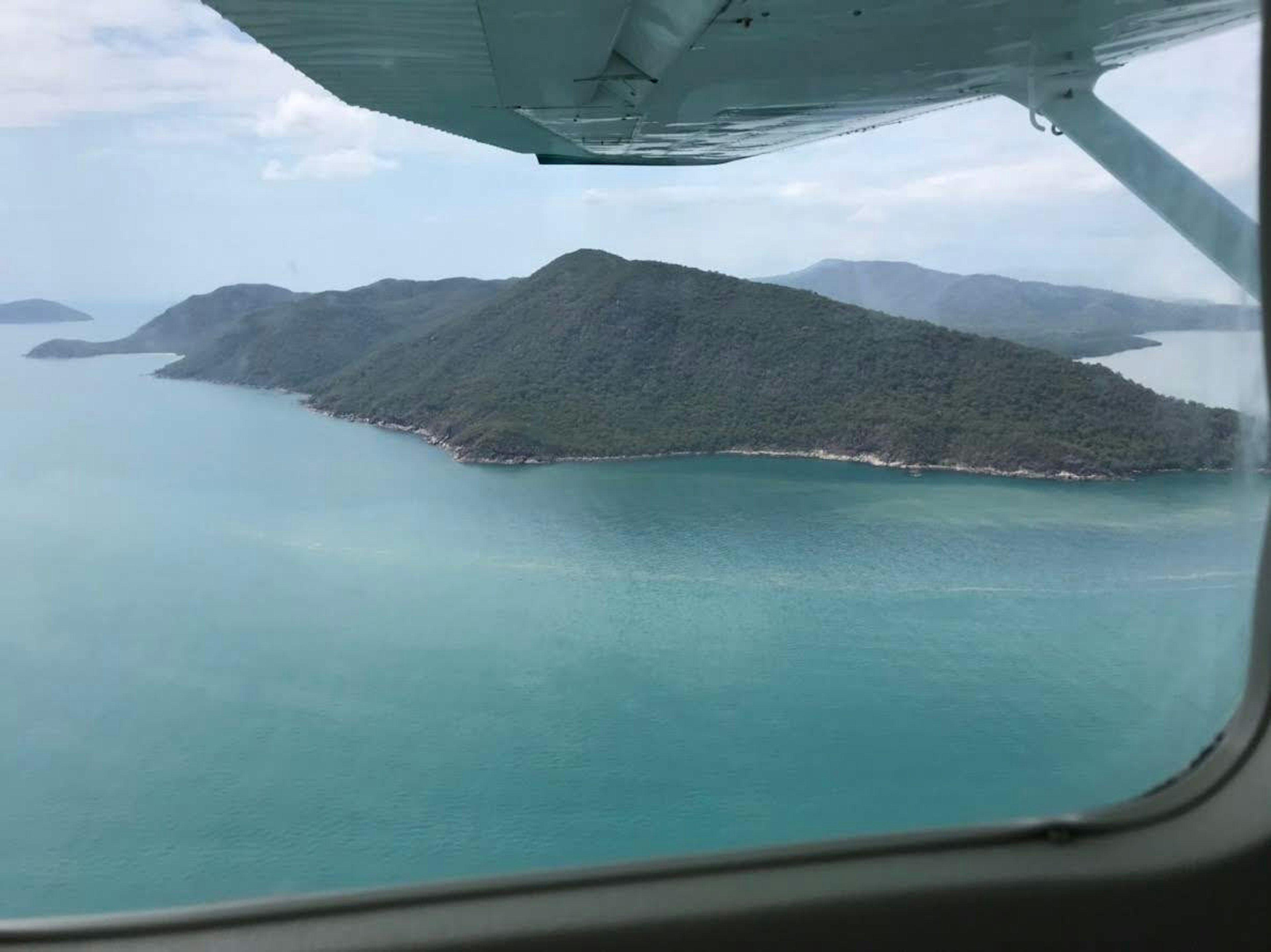 Aerial view of a lush green island surrounded by turquoise waters