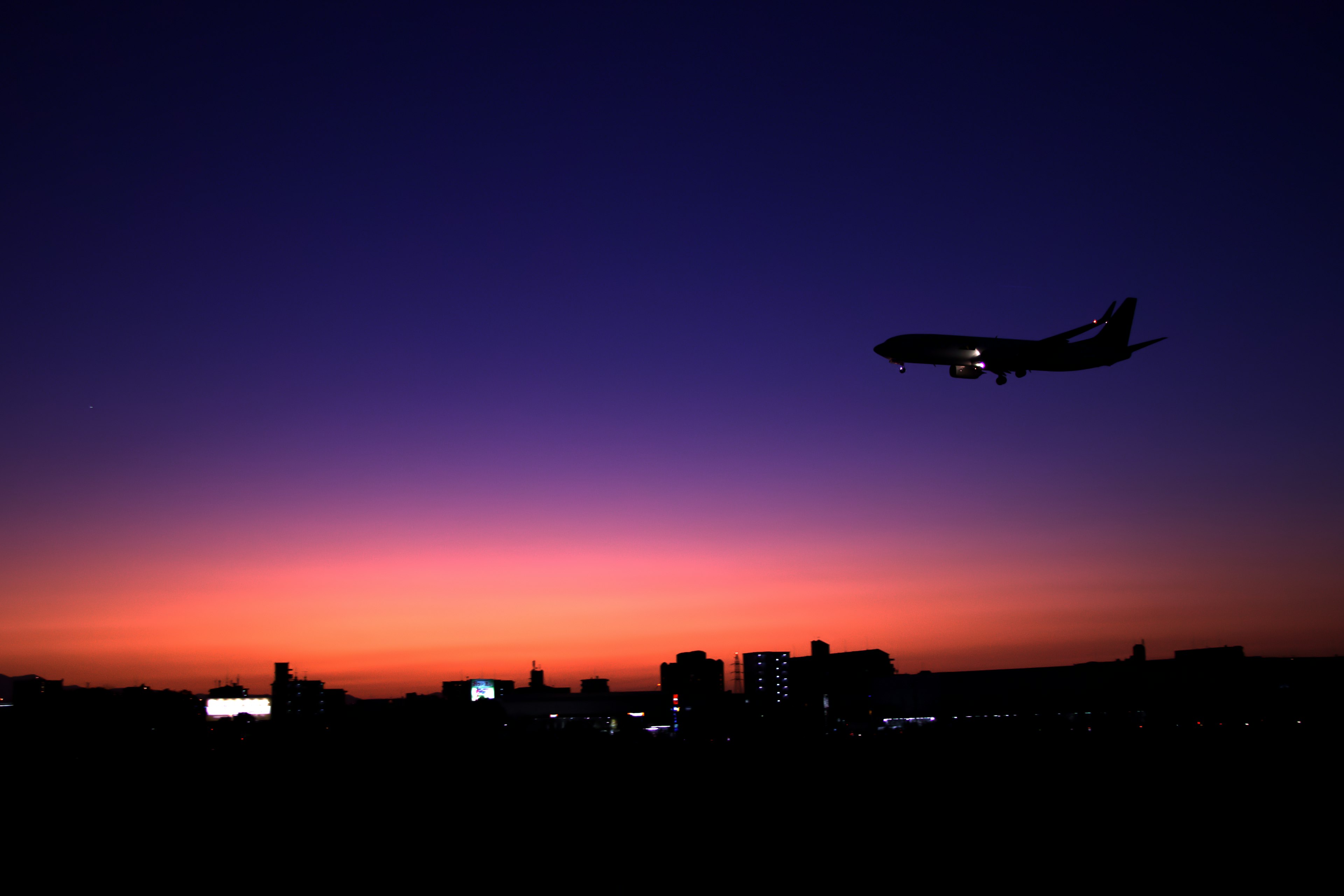 夕焼けの空を背景に飛行機が着陸するシーン