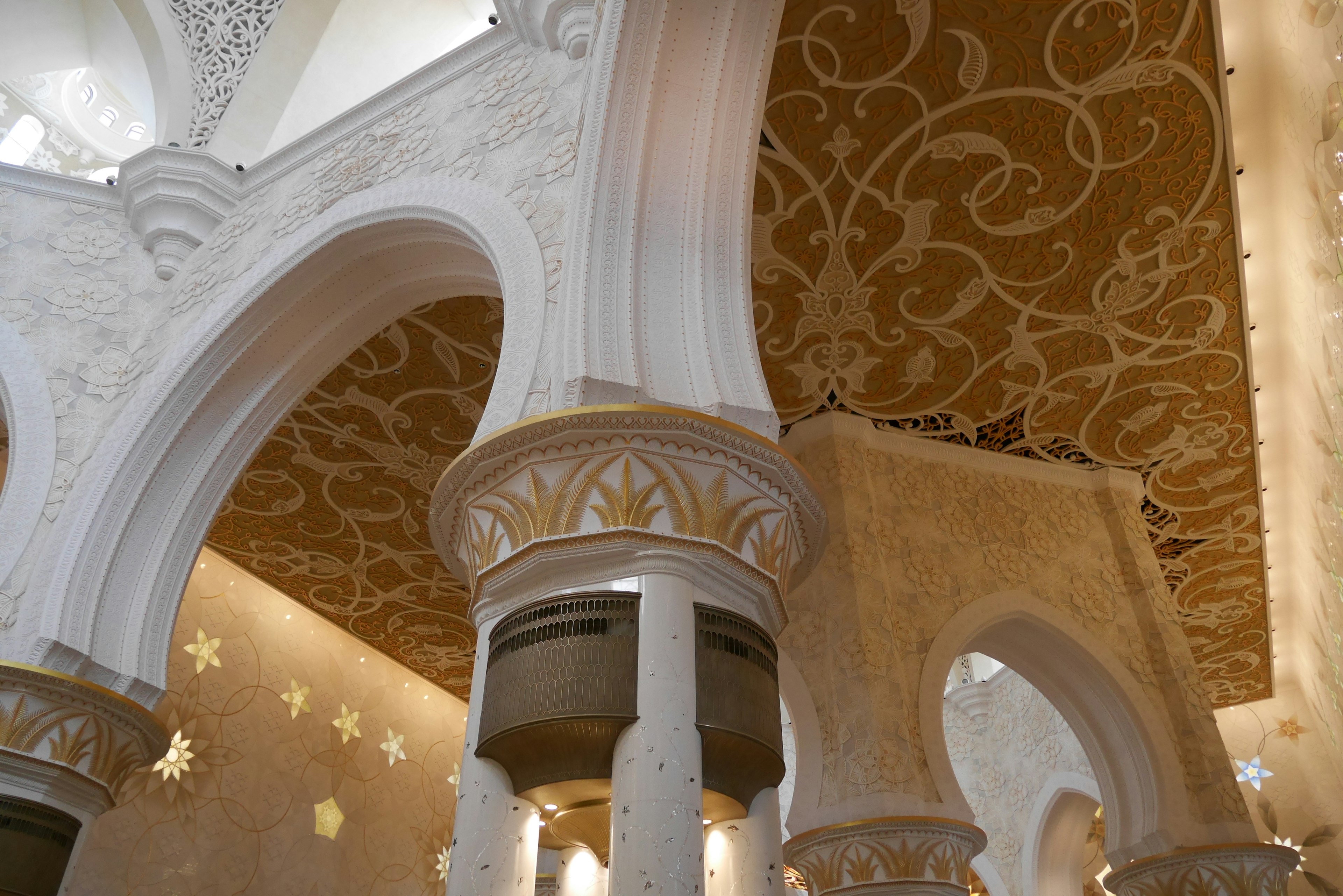 Luxurious interior featuring white columns and a golden ceiling