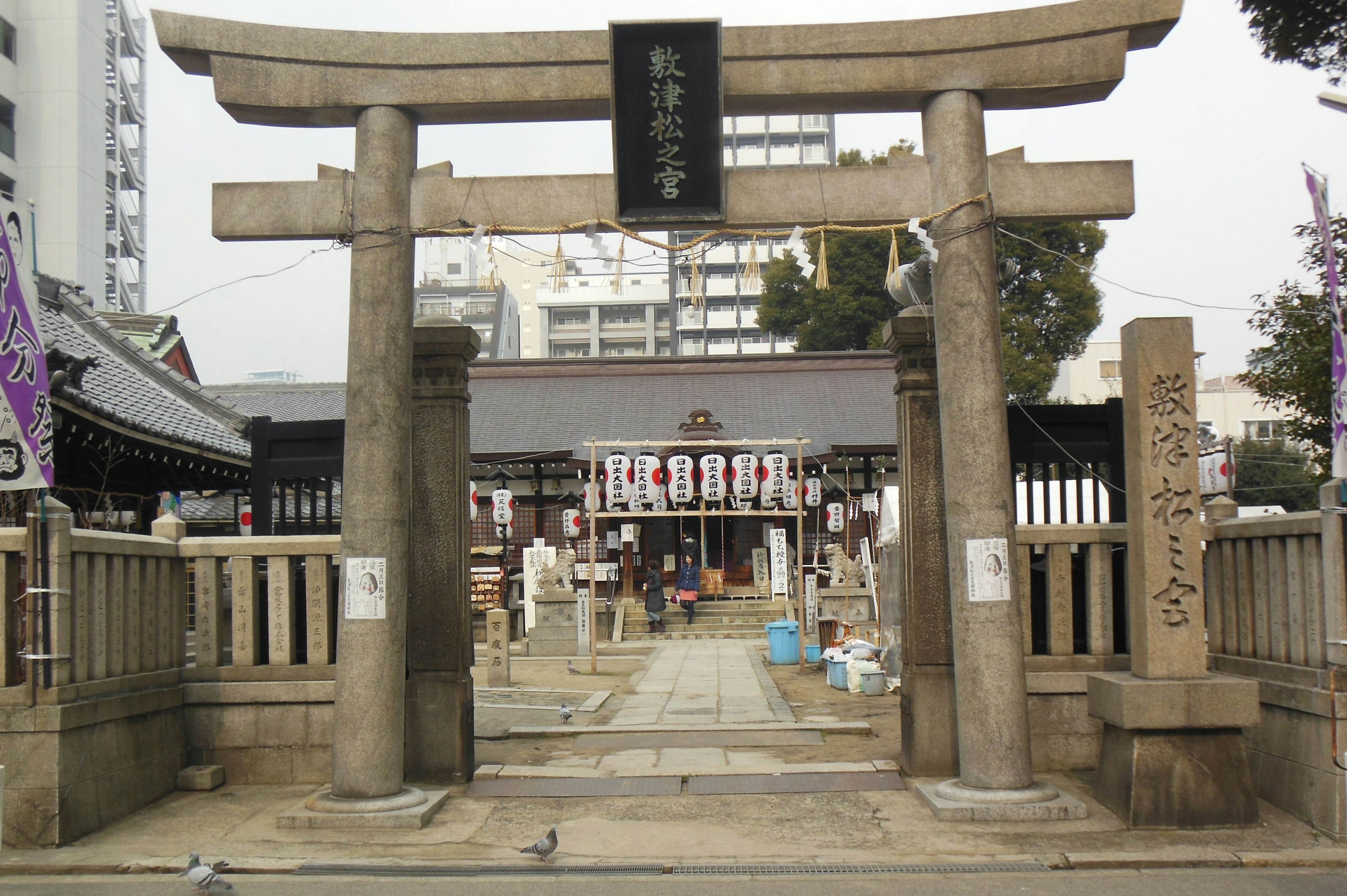 Urban landscape featuring a shrine torii gate and entrance