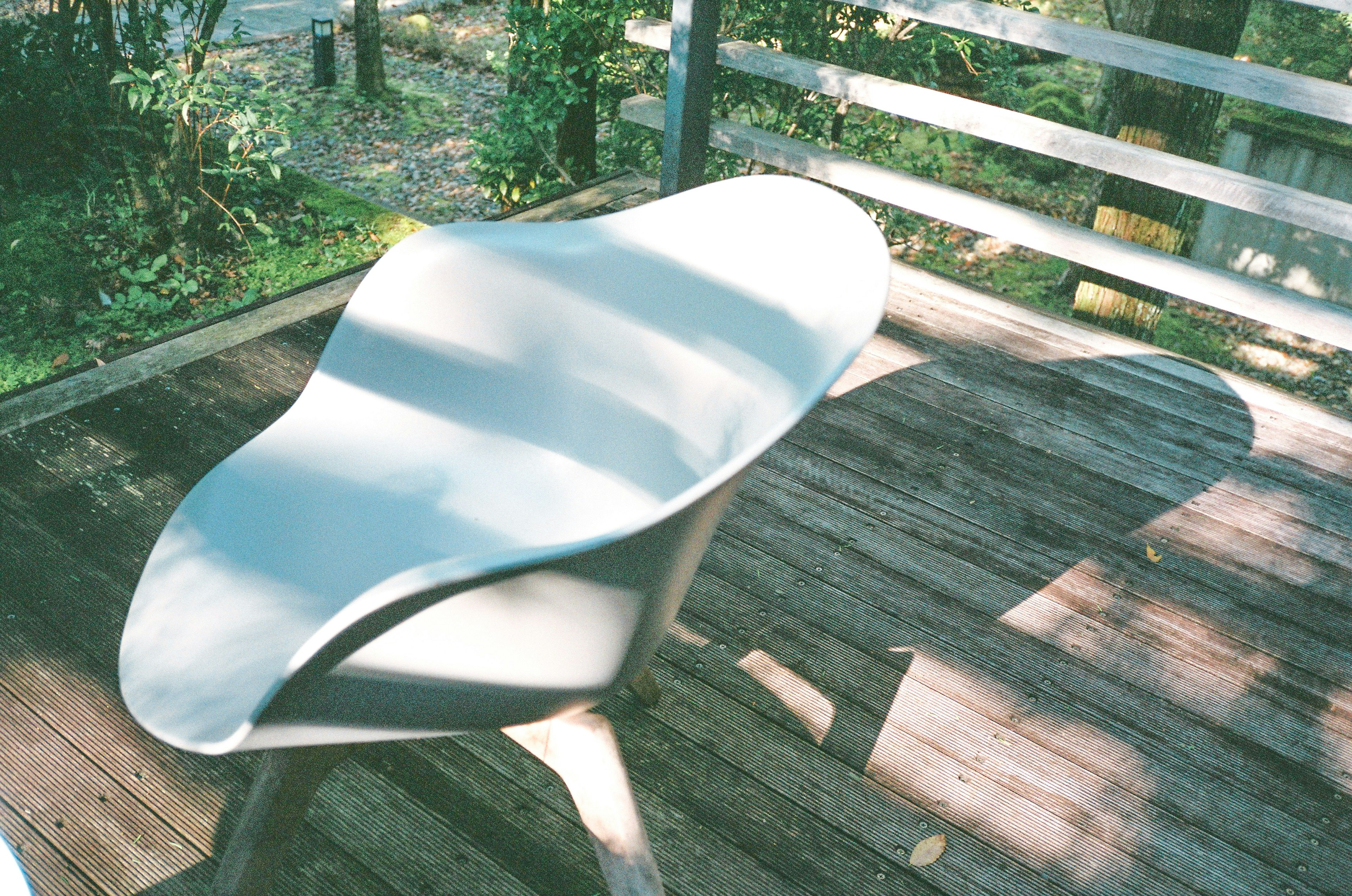 Moderne Stuhl auf einem Holzdeck mit Licht- und Schattenspiel