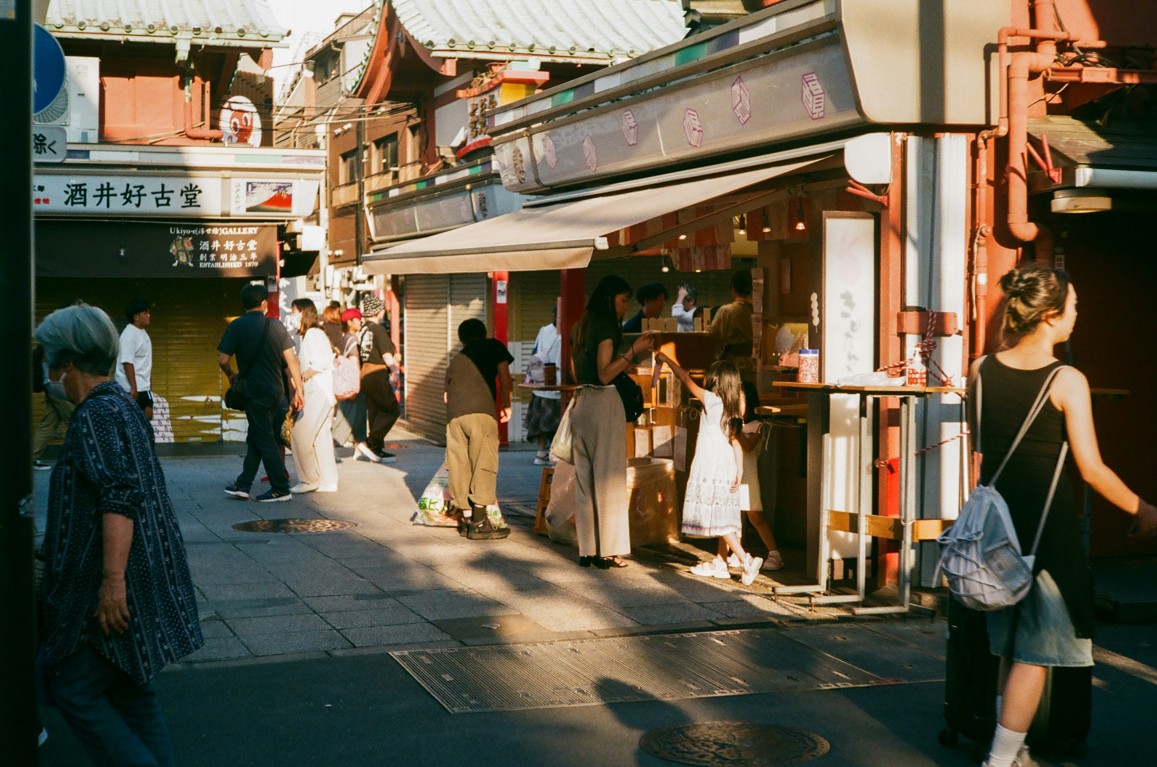 賑やかな街角で人々が行き交う様子と店舗が並ぶ風景