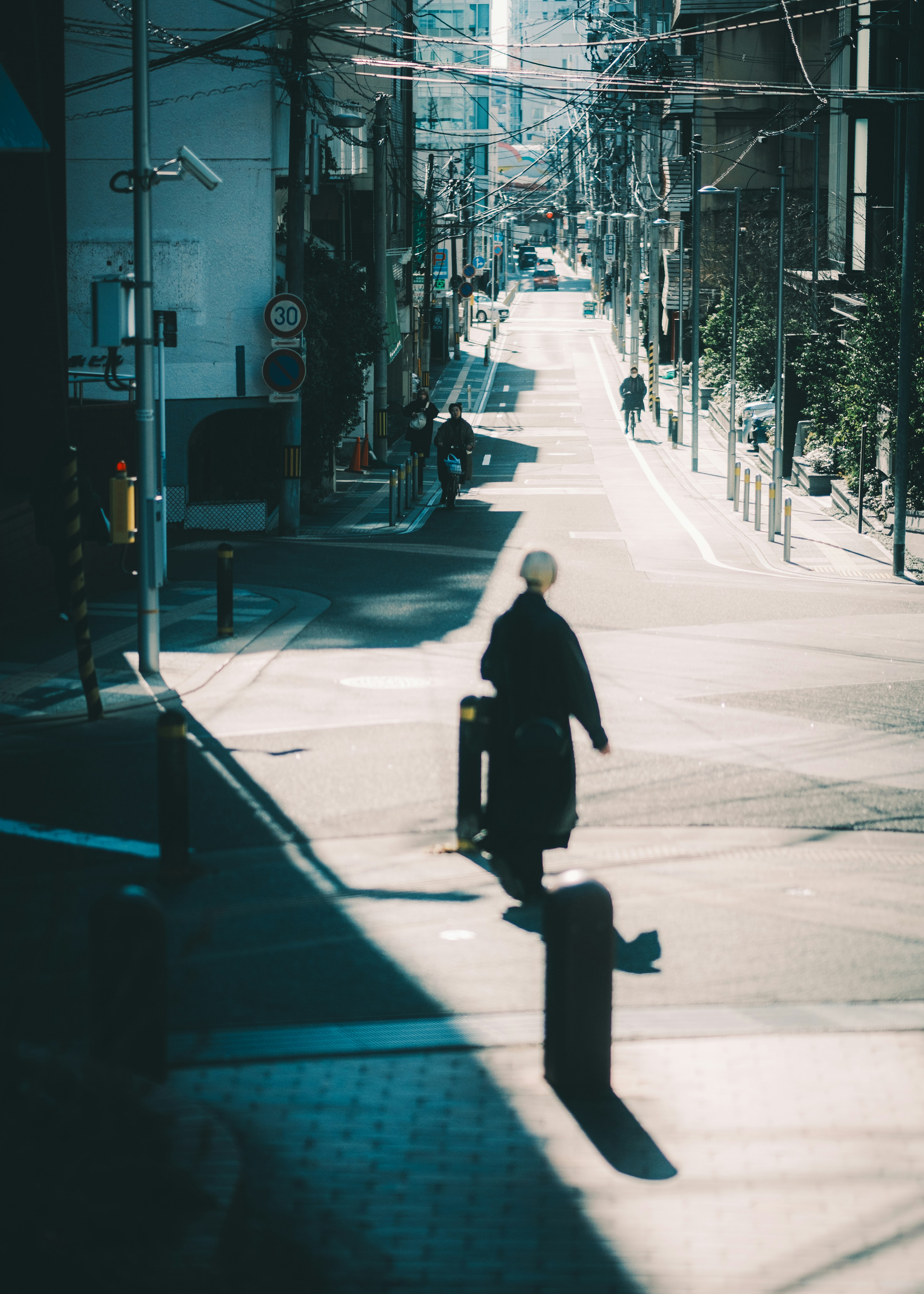 A person walking down a quiet street with a long shadow