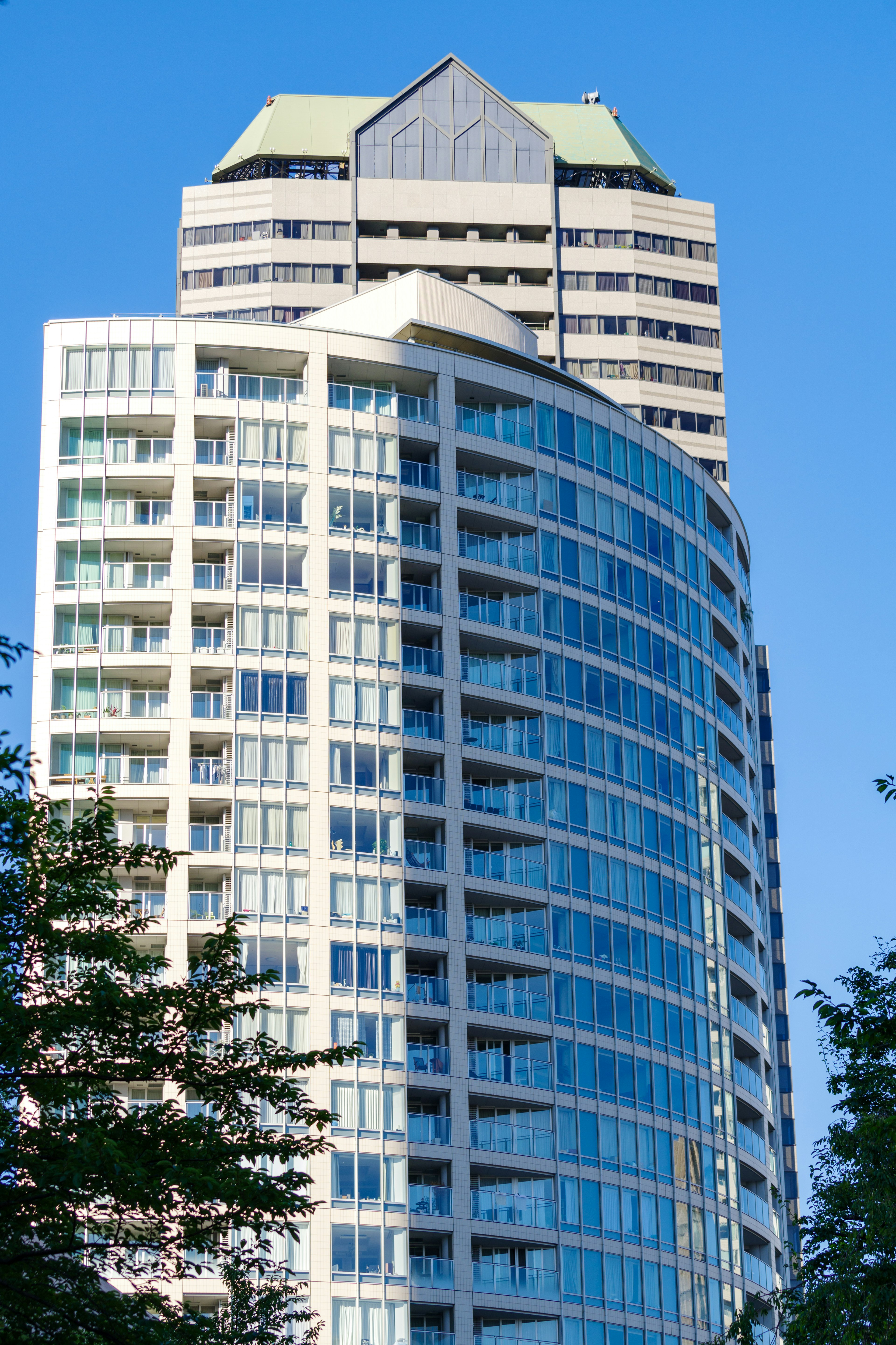 Moderner Wolkenkratzer mit gekrümmtem Design vor blauem Himmel