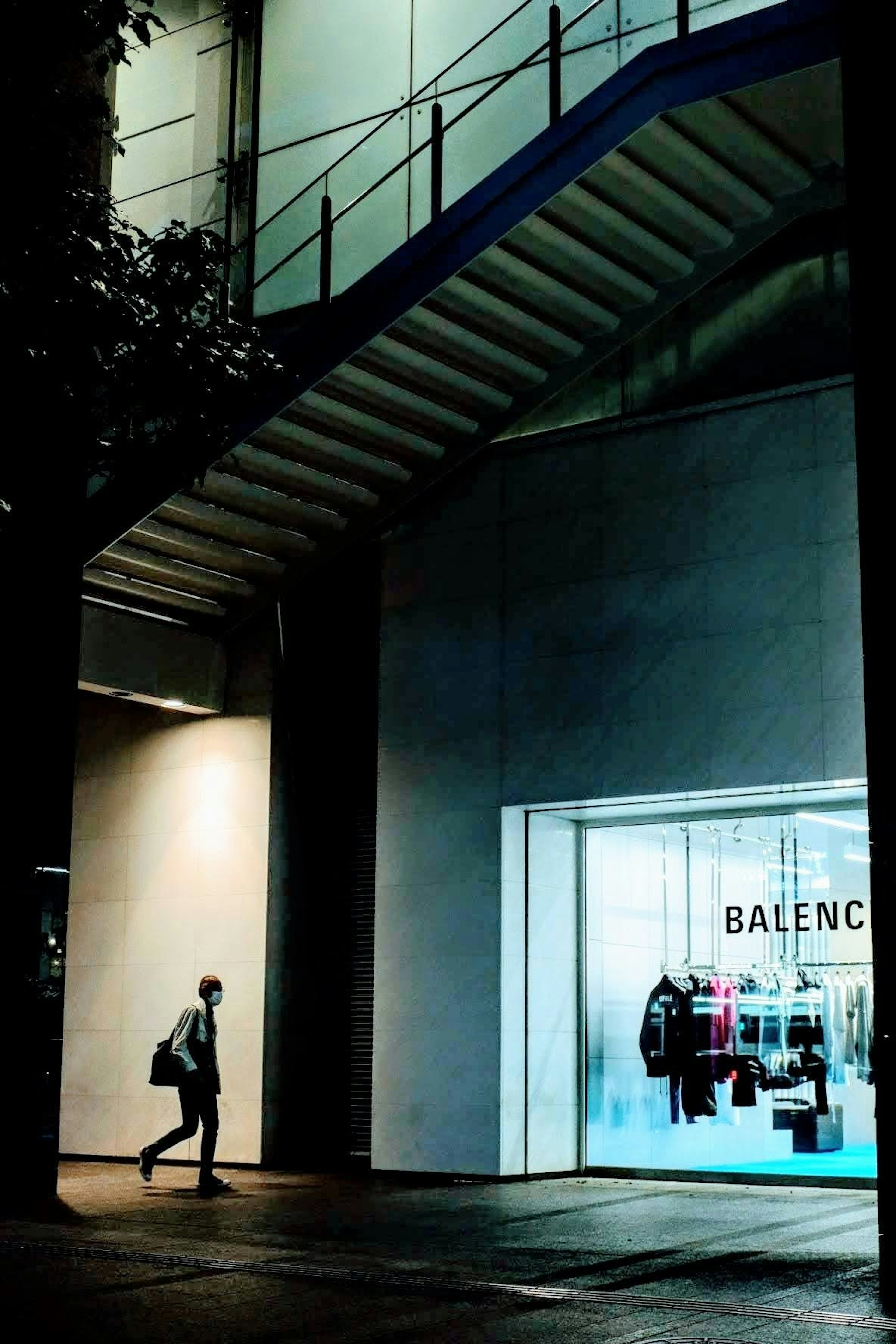 คนเดินอยู่บนถนนมืดใกล้ร้าน Balenciaga