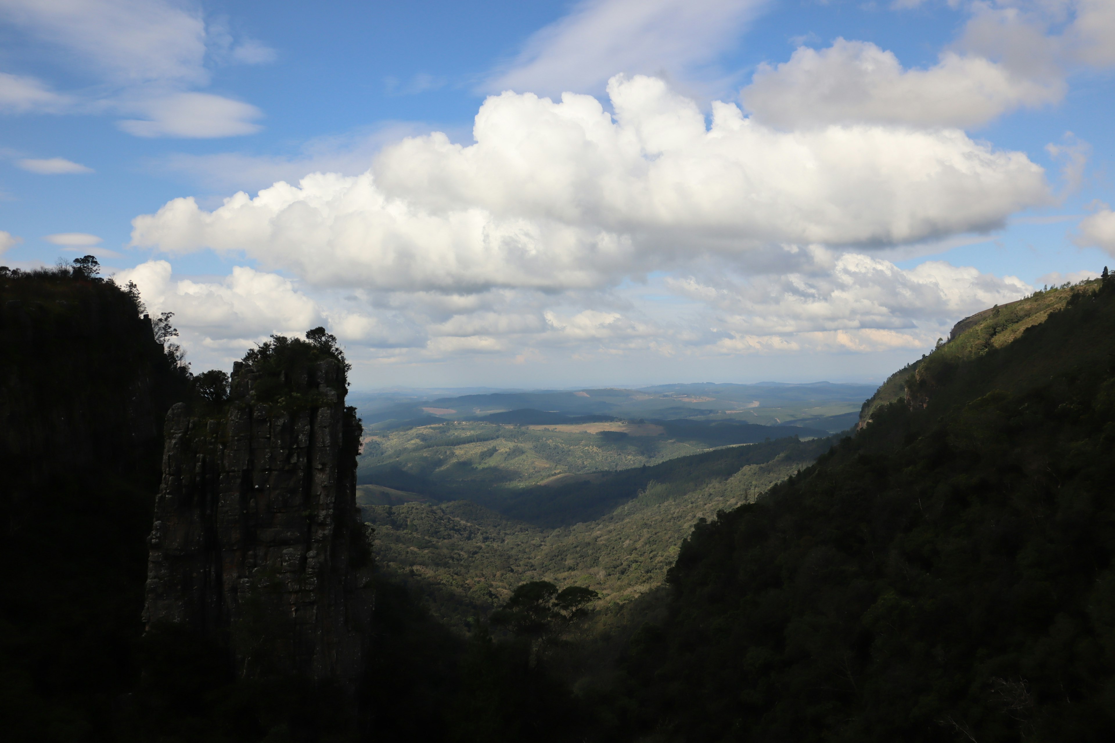 Scenic view of green valleys and mountains under a blue sky