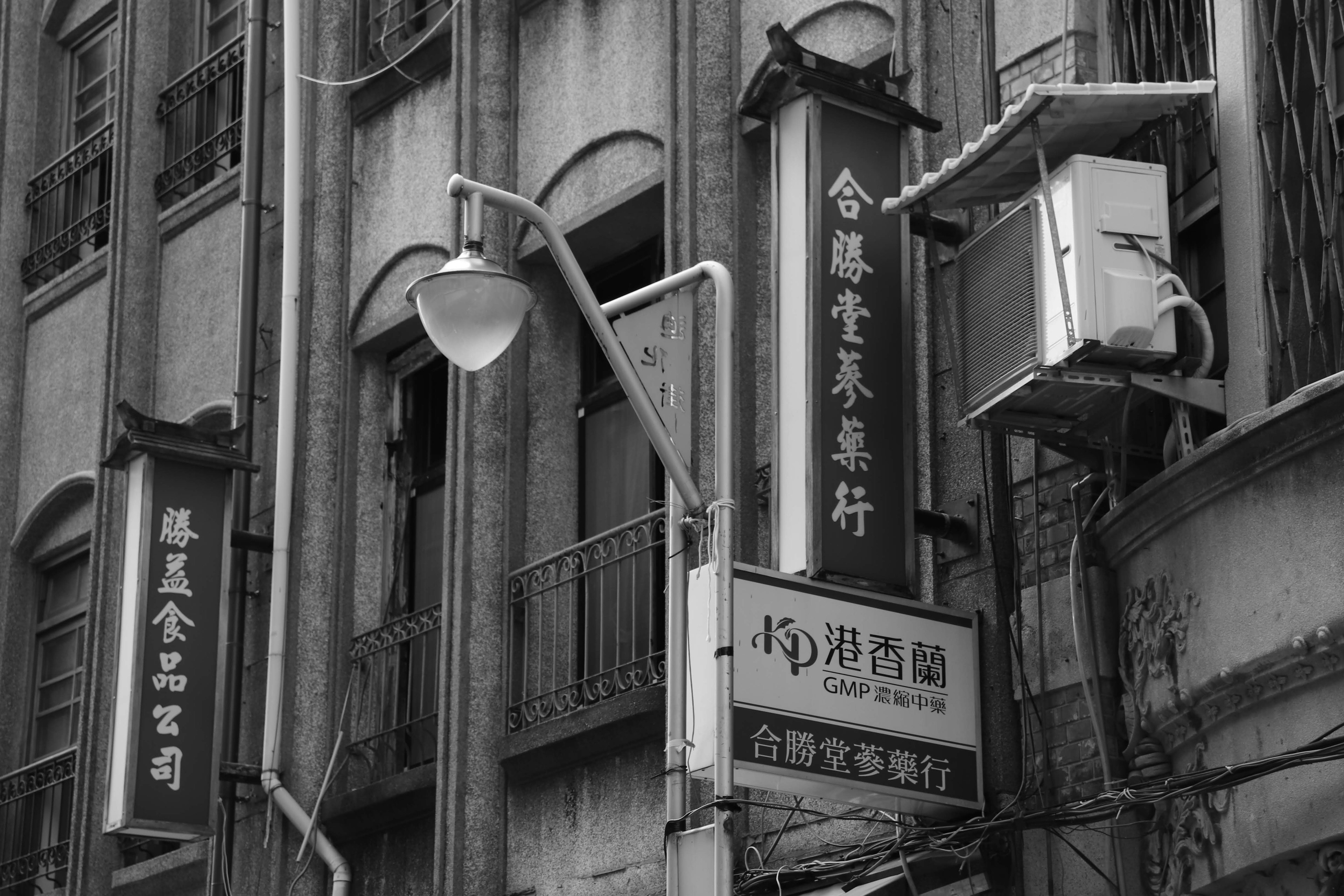 Antiguas señales y farola en un entorno urbano en blanco y negro