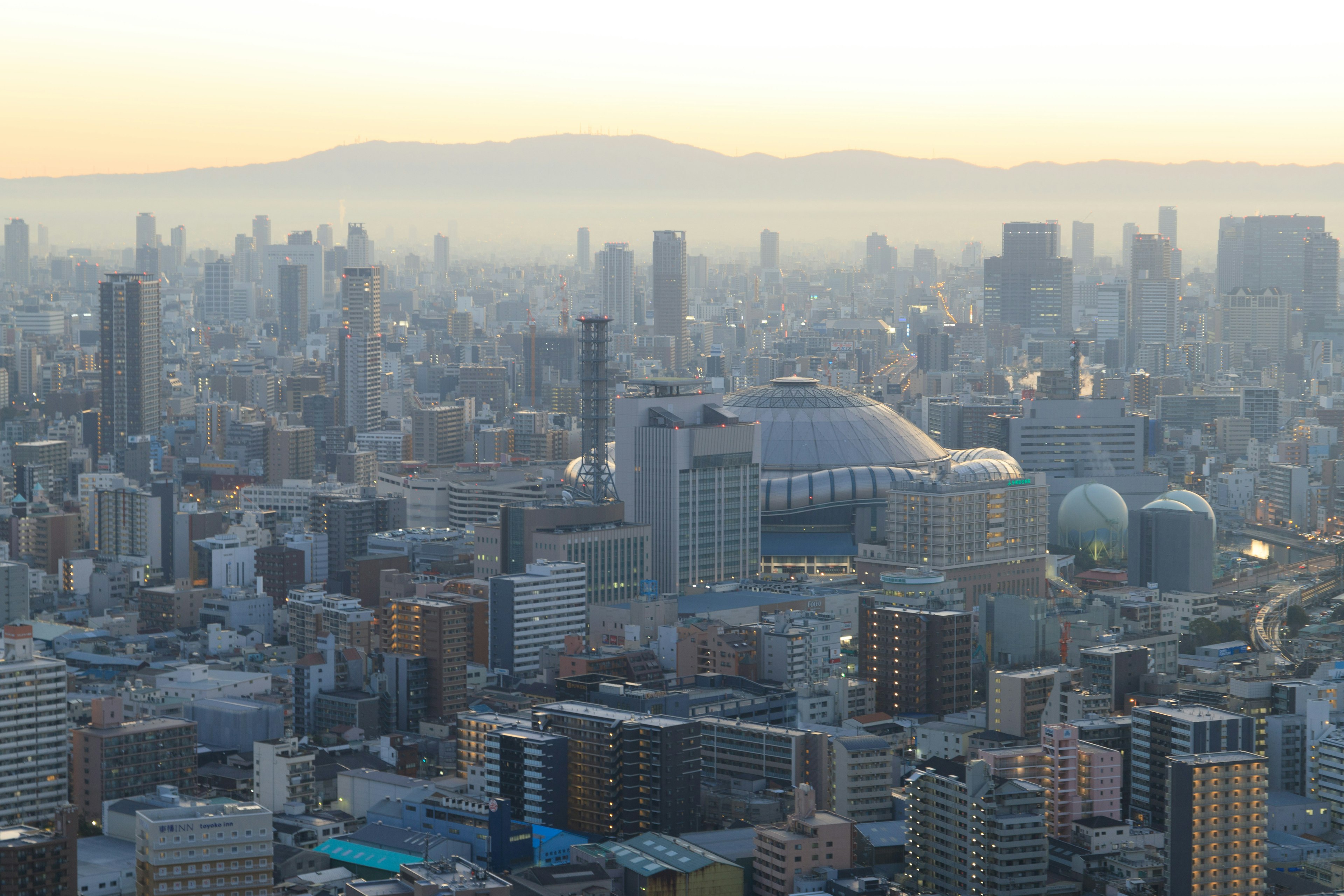 Vista aérea del paisaje urbano de Osaka con rascacielos y montañas distantes