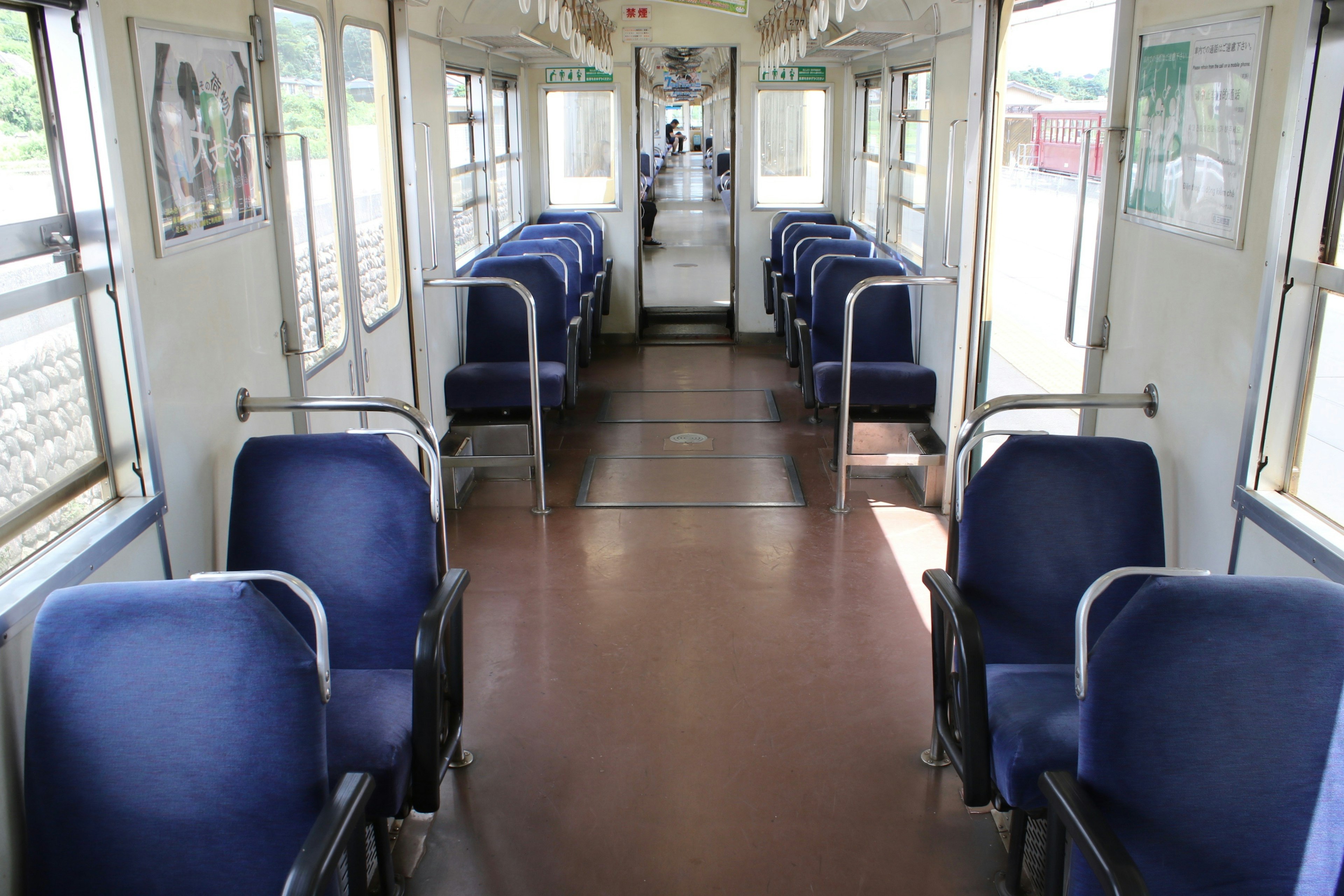 Interior de un tren con asientos azules vacíos