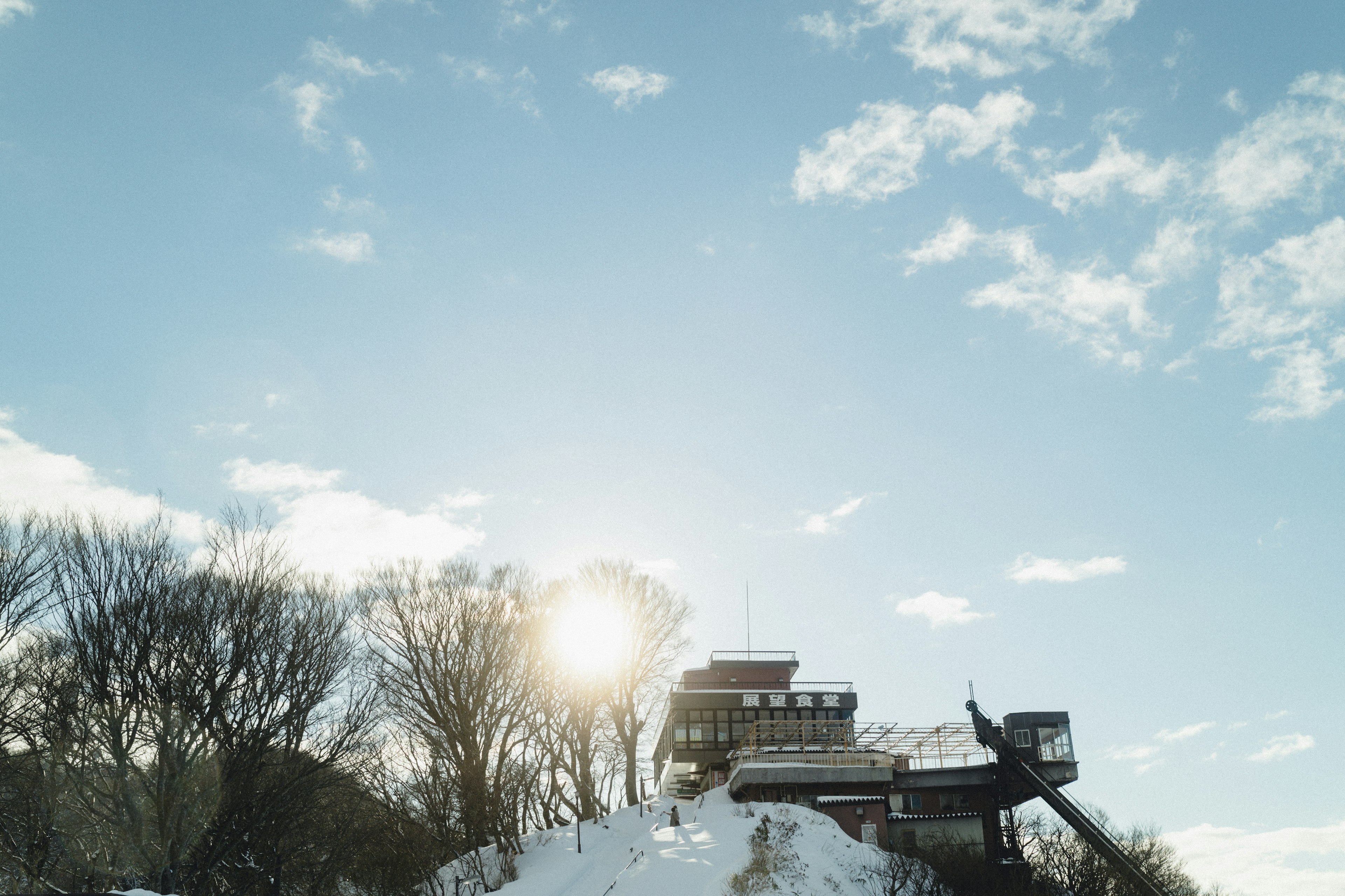 Building on a snowy hill under a bright blue sky