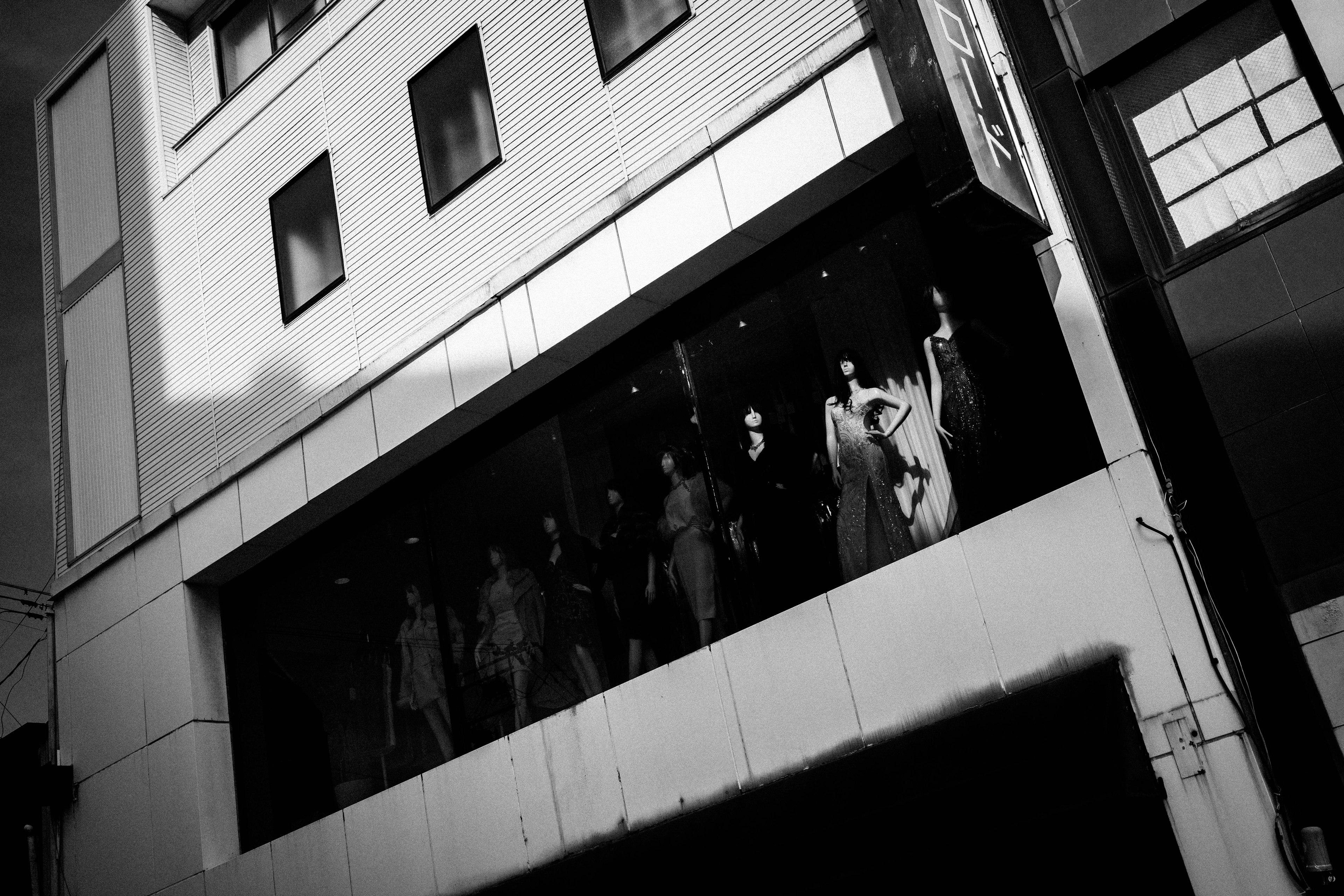 Photo en noir et blanc de personnes debout au deuxième étage d'un bâtiment