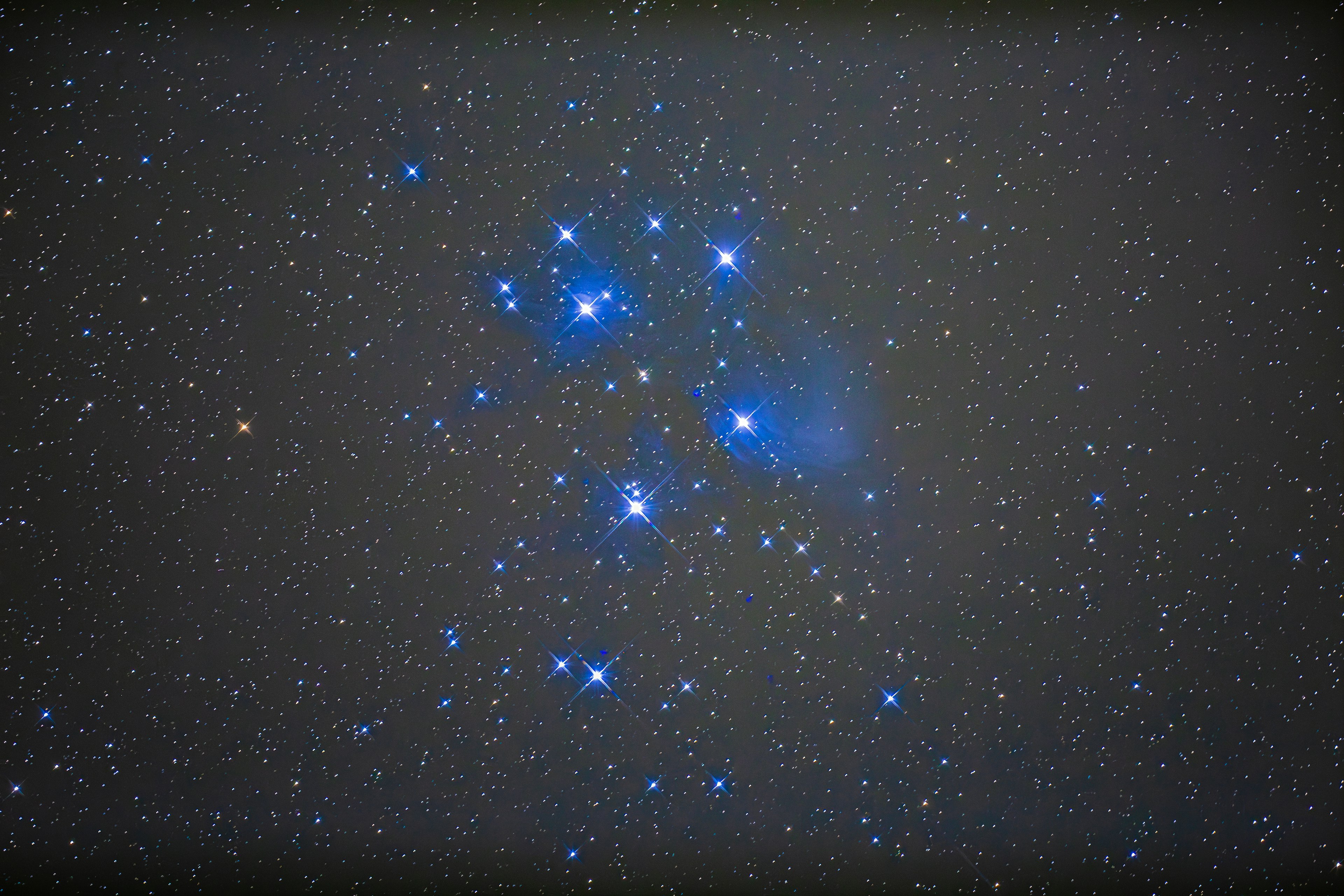 Ansammlung von leuchtend blauen Sternen am Nachthimmel mit Nebel