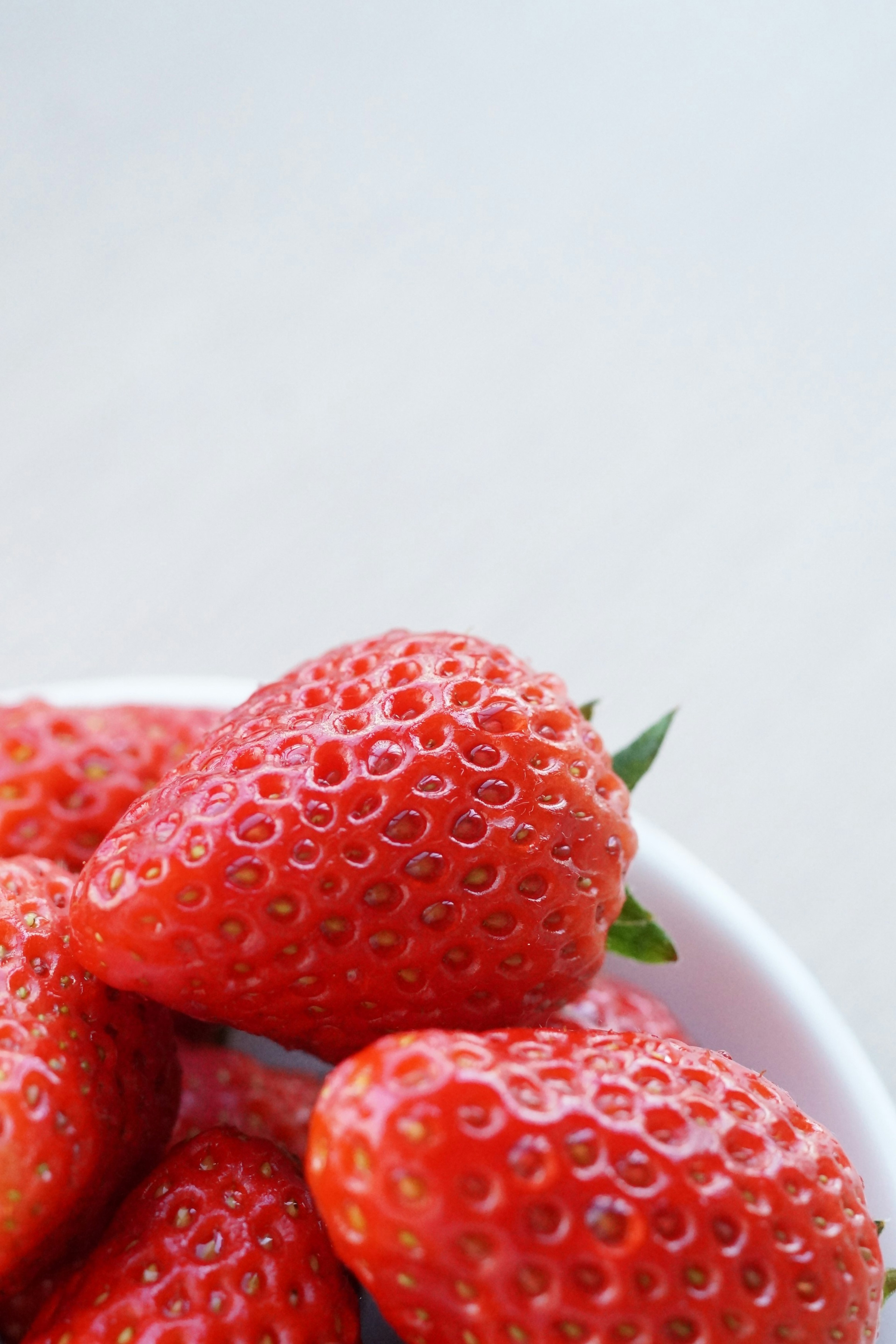 Imagen en primer plano de fresas frescas que muestran un color rojo vibrante y hojas verdes