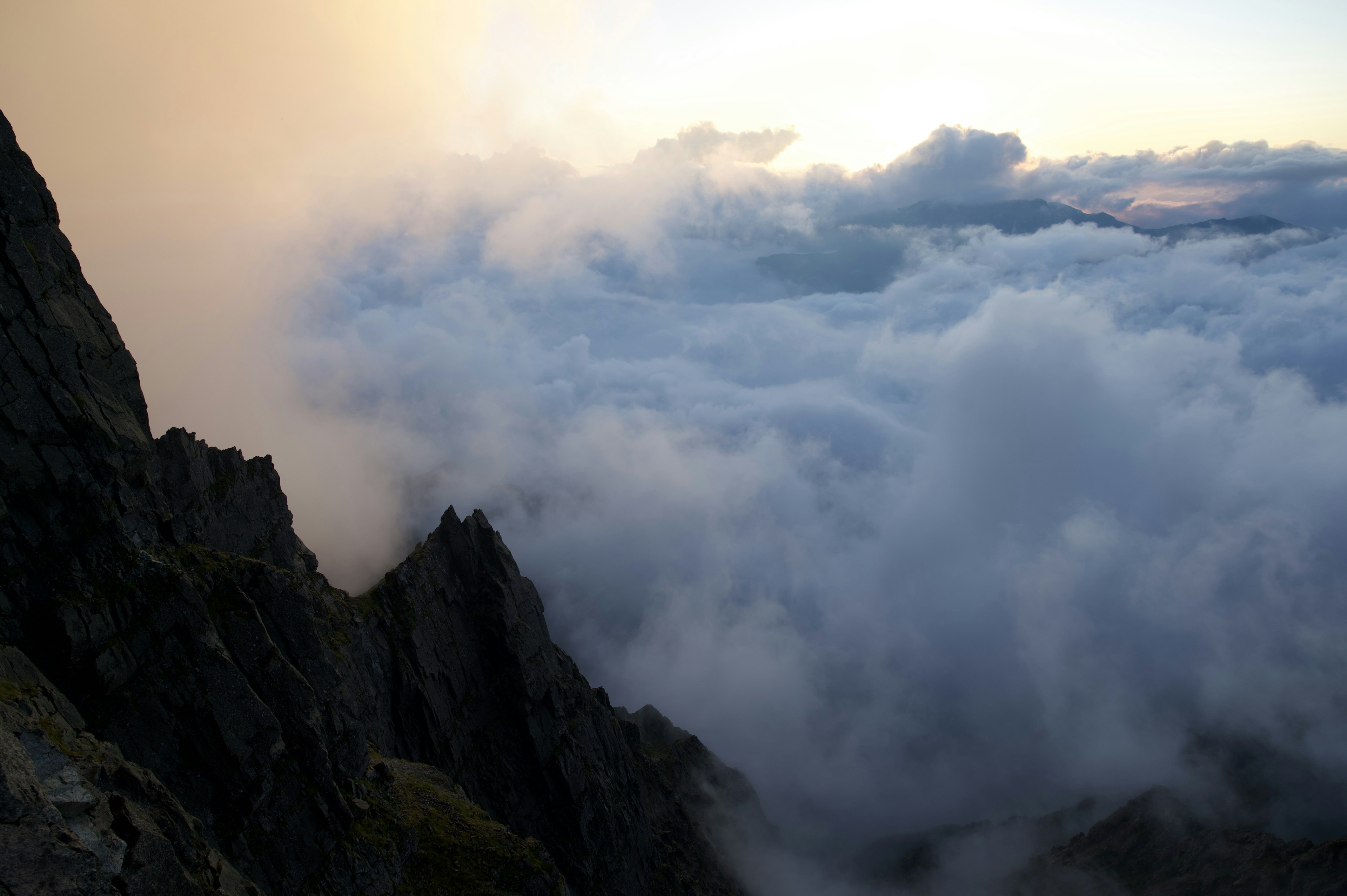 Nubes cubriendo un paisaje montañoso al atardecer