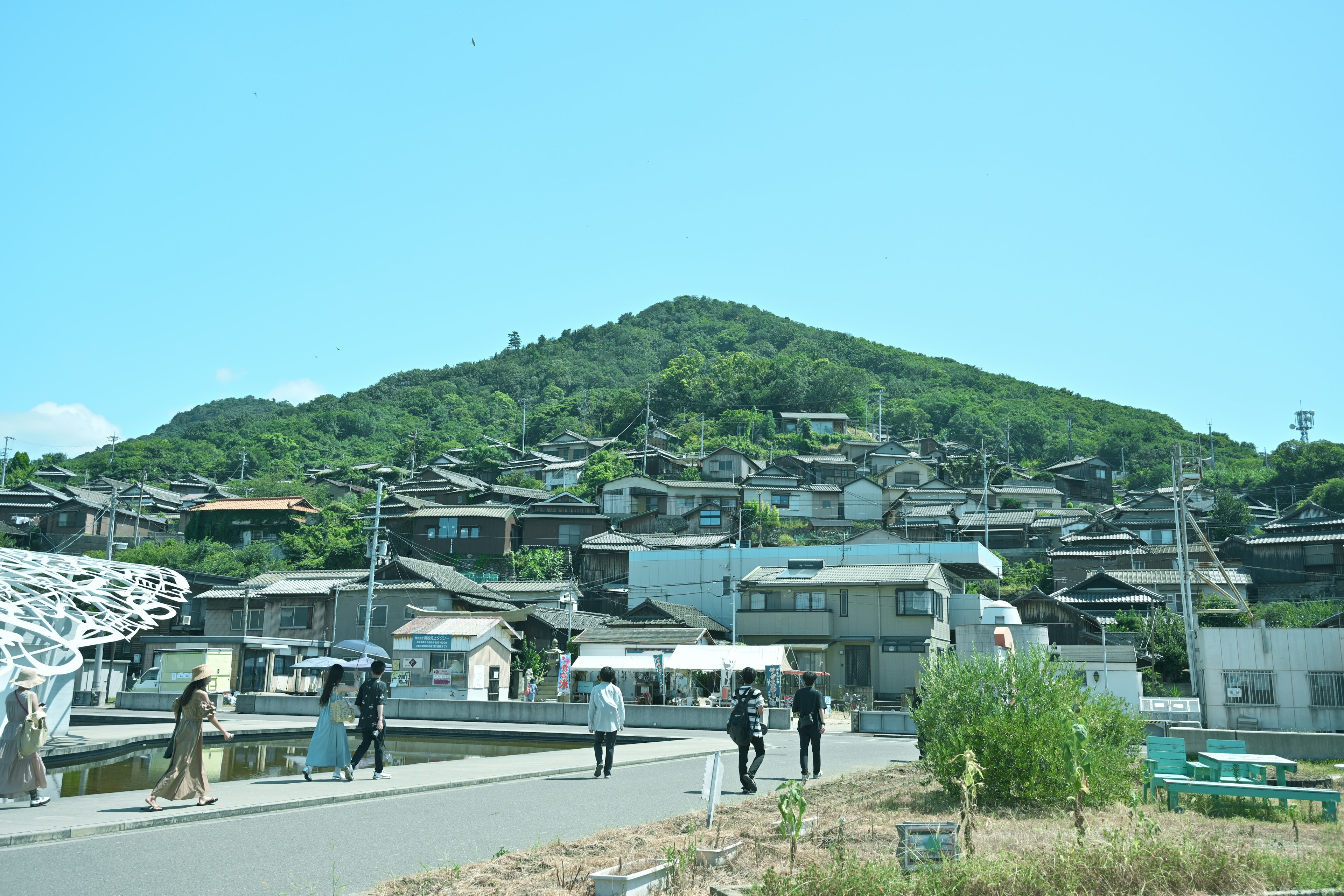 Casas en una colina verde con personas caminando en primer plano