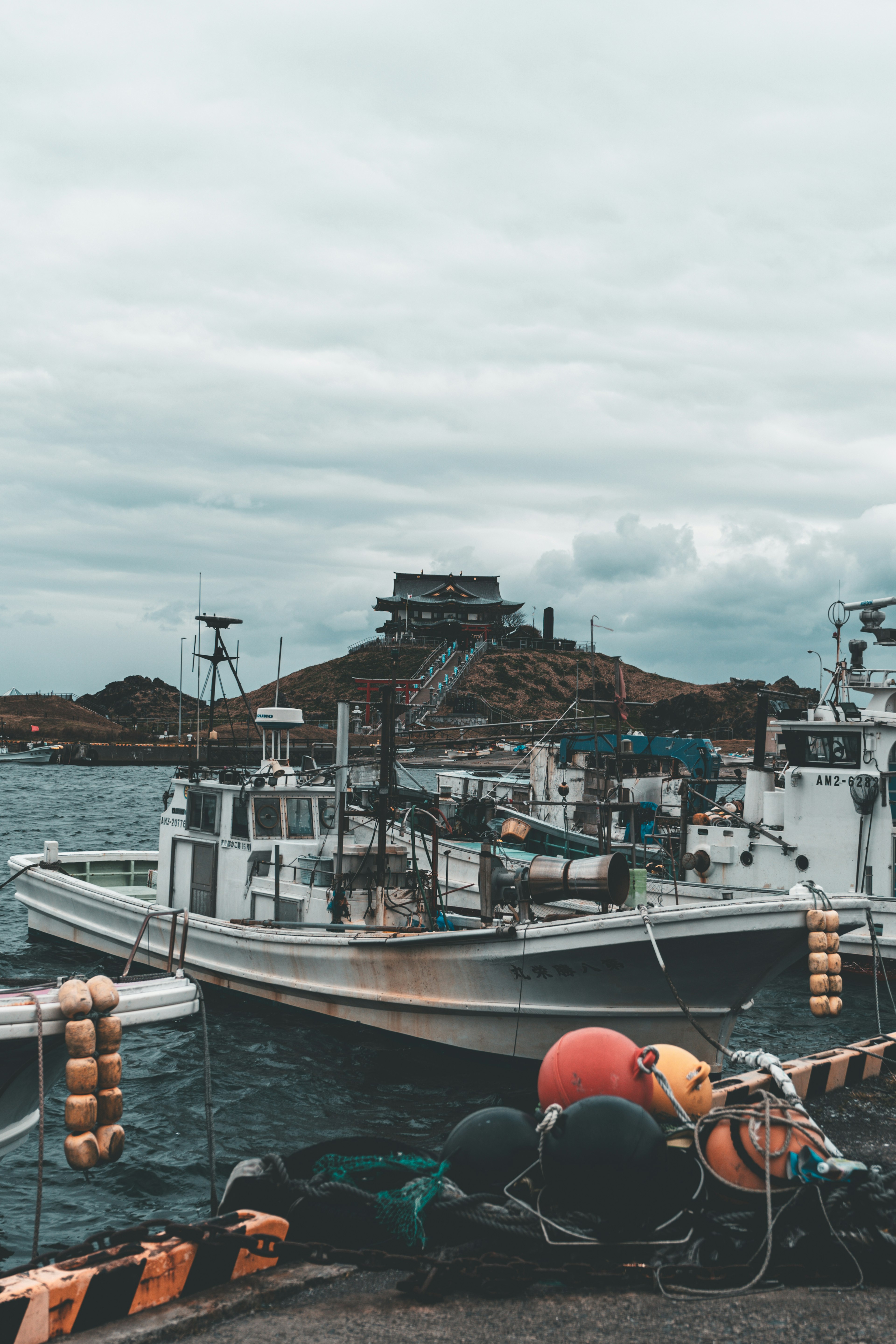 Fishing boats docked at a harbor with buoys visible