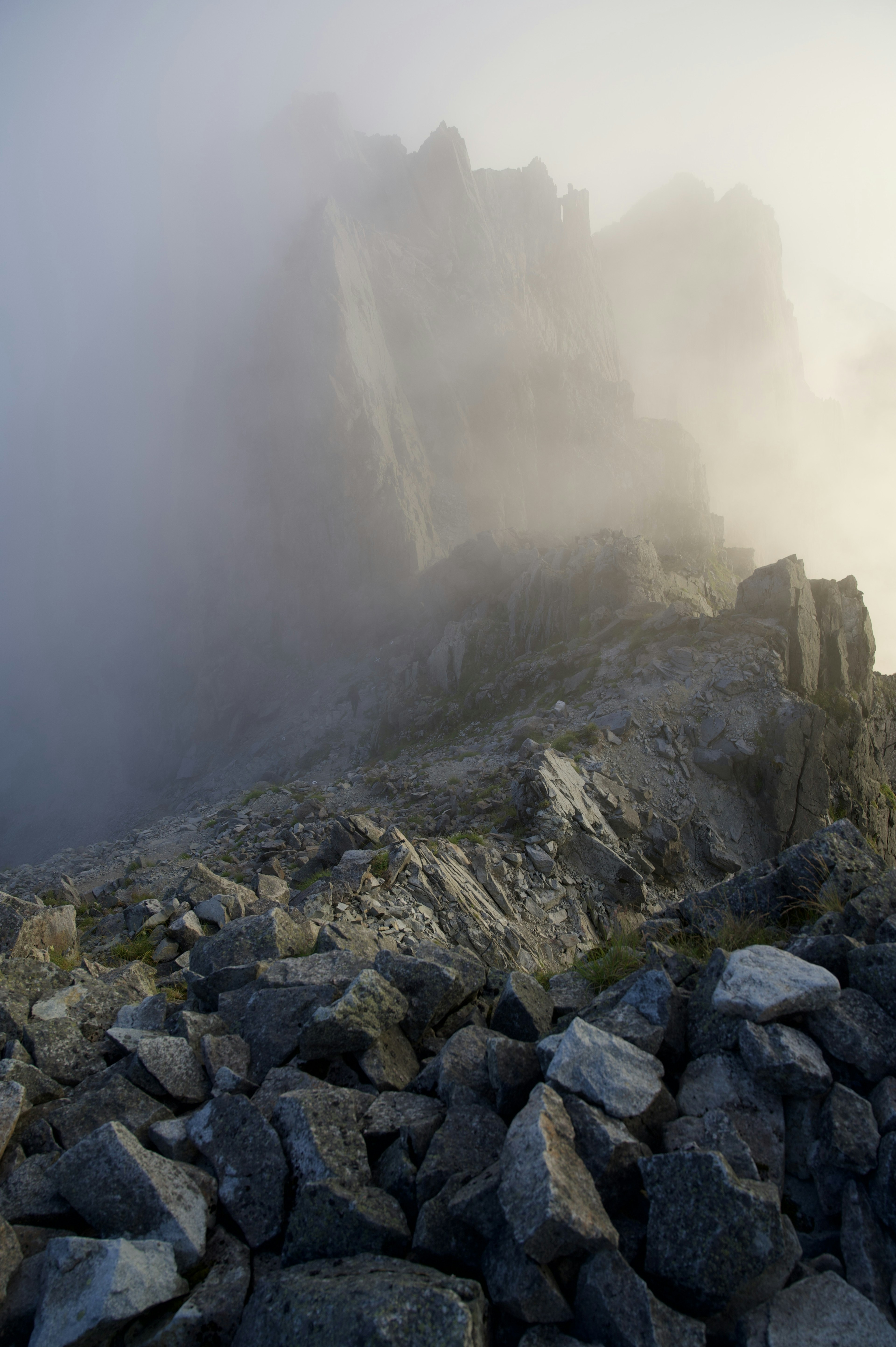 Mountain landscape enveloped in fog with rocky terrain