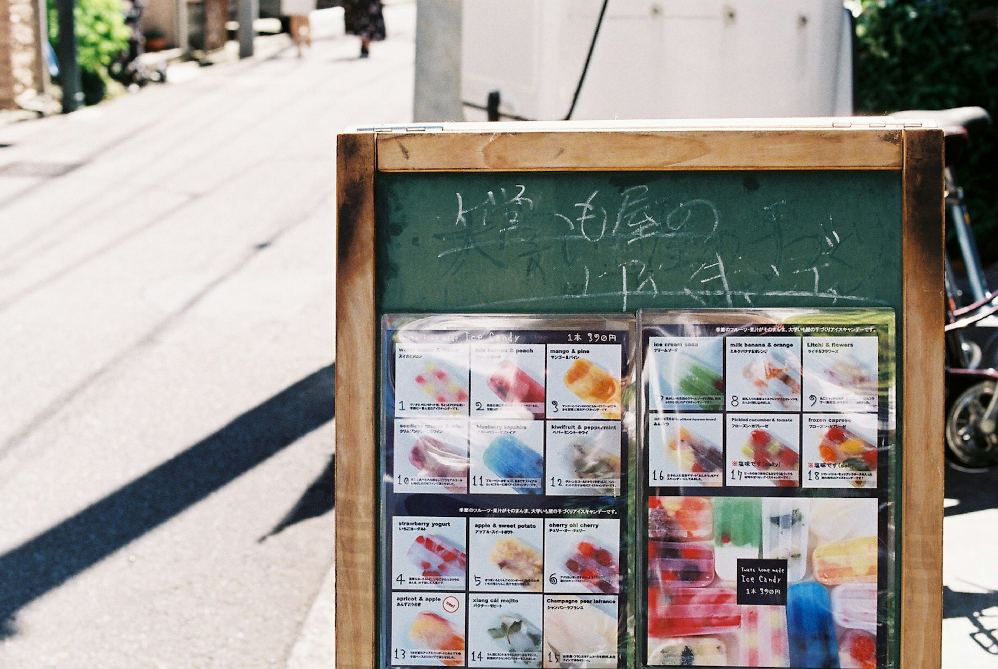 Papan menu di sudut jalan menampilkan minuman berwarna-warni