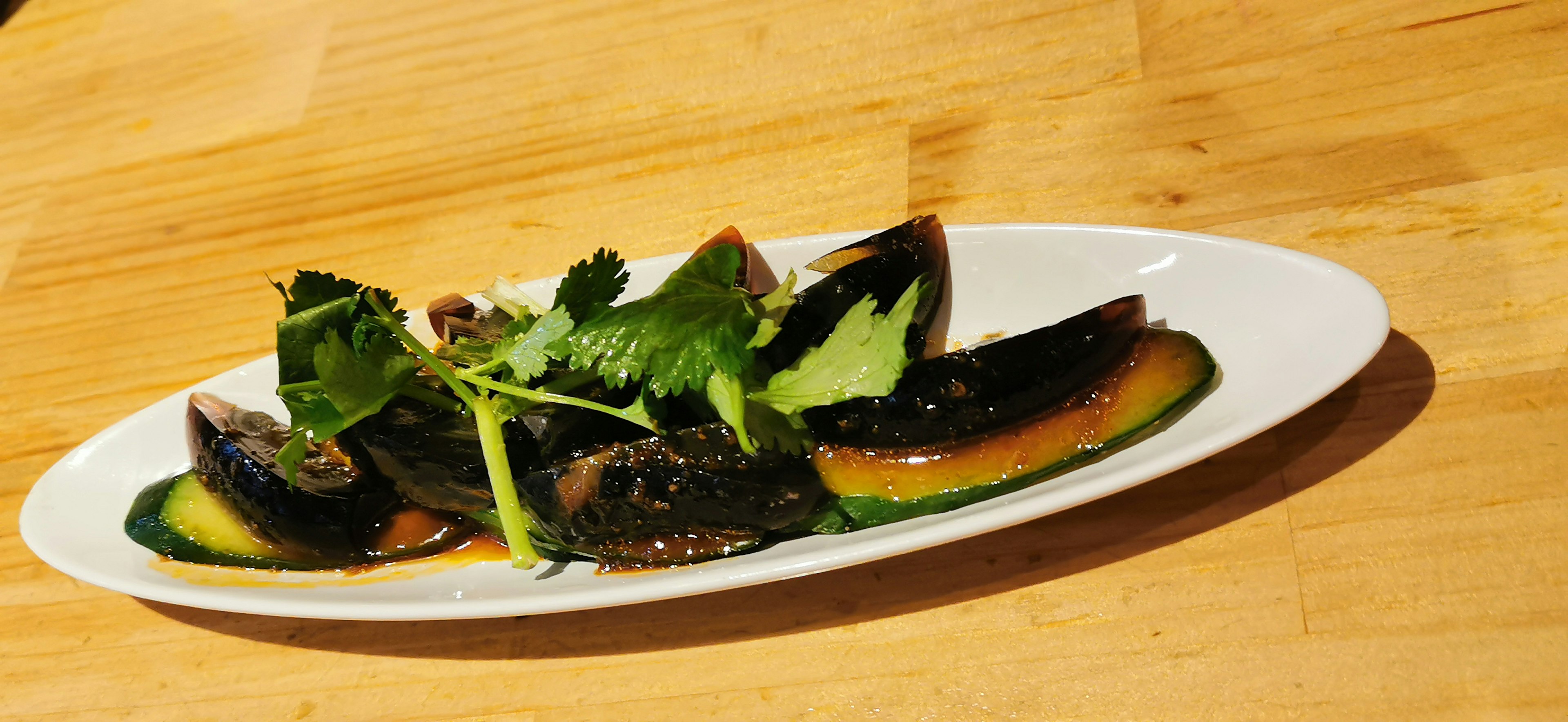 Plated black mussels garnished with fresh green herbs