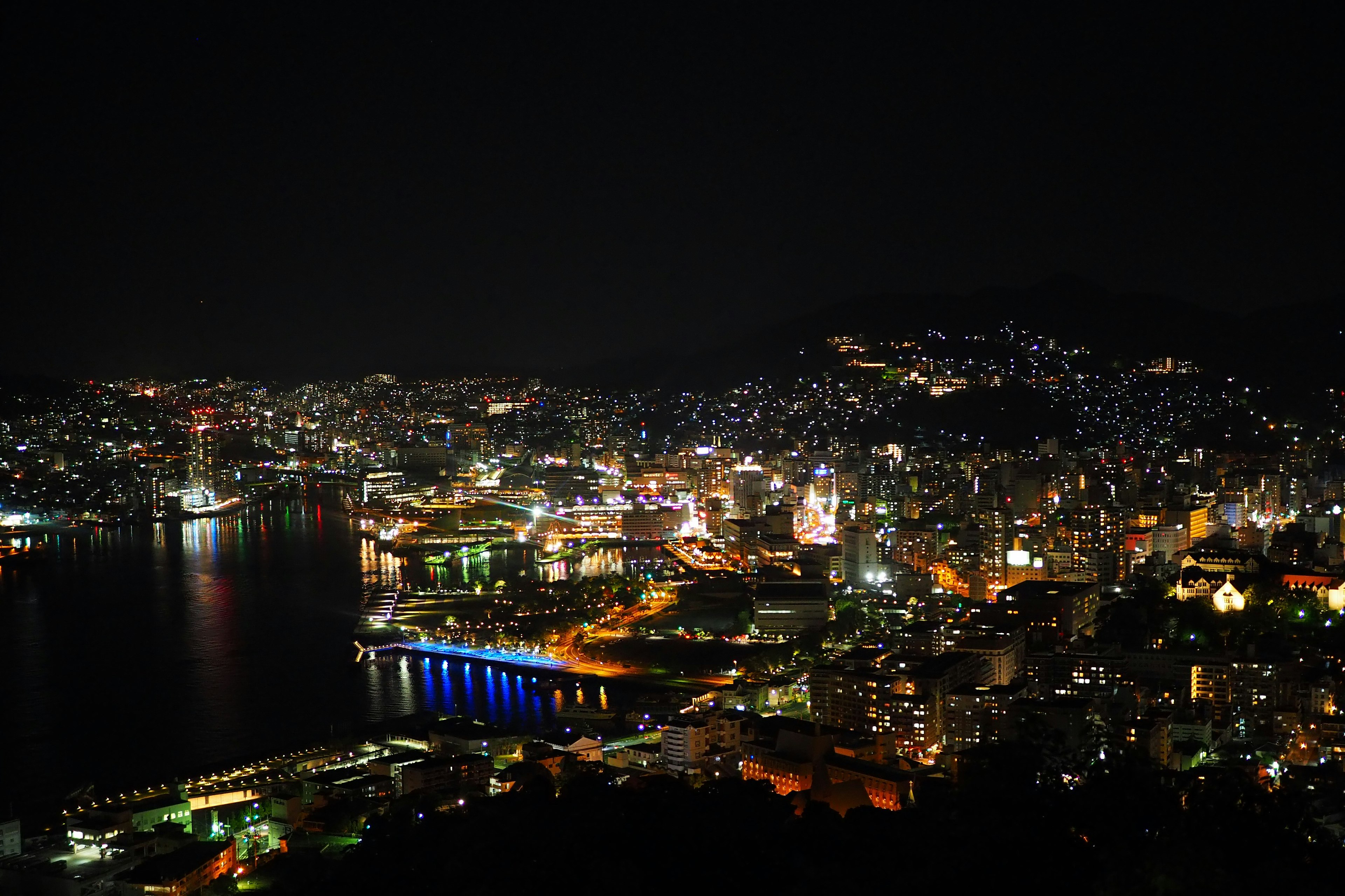 Hermosa vista nocturna de una ciudad y el mar