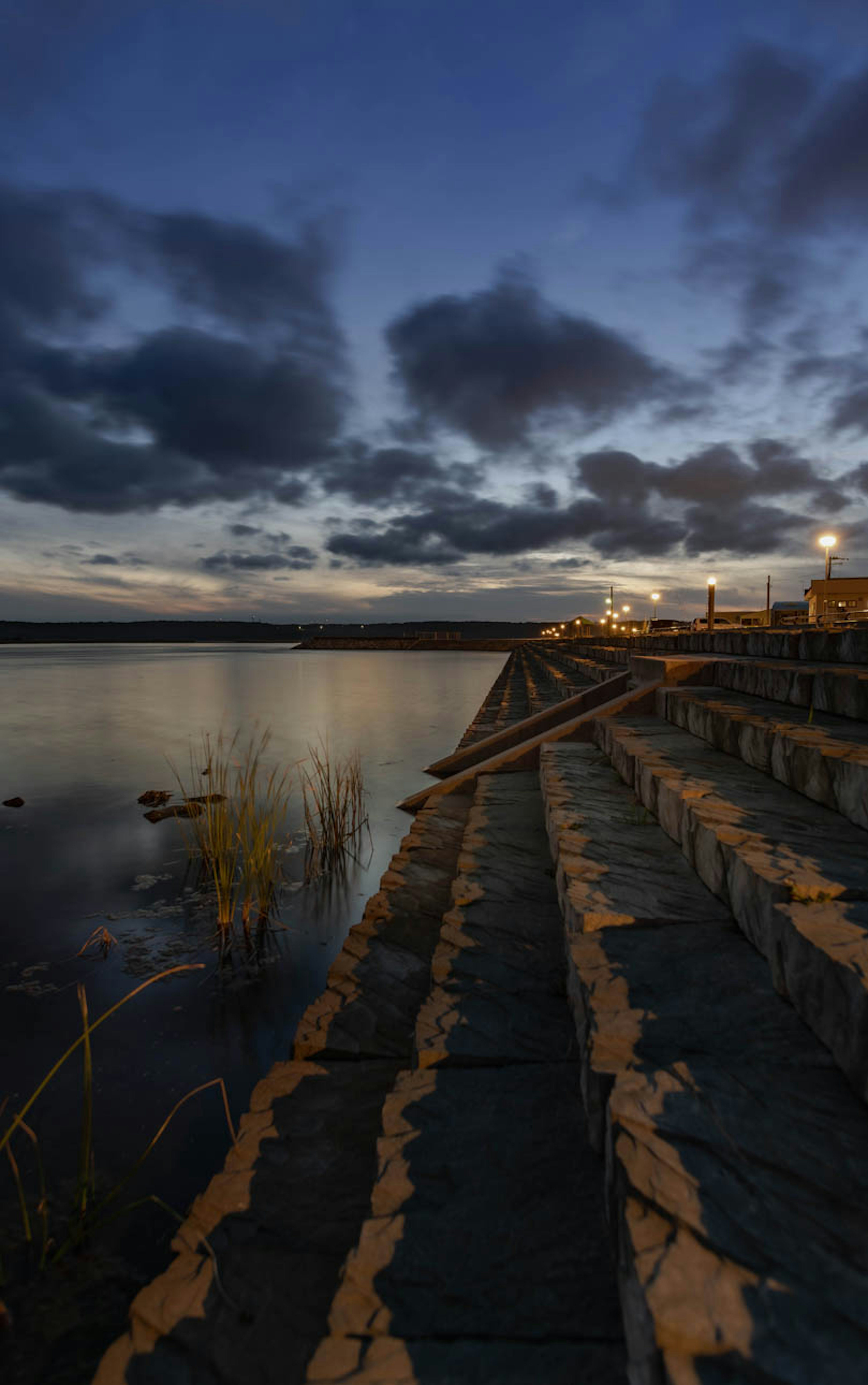 Steinstufen am See, die den Dämmerungshimmel widerspiegeln