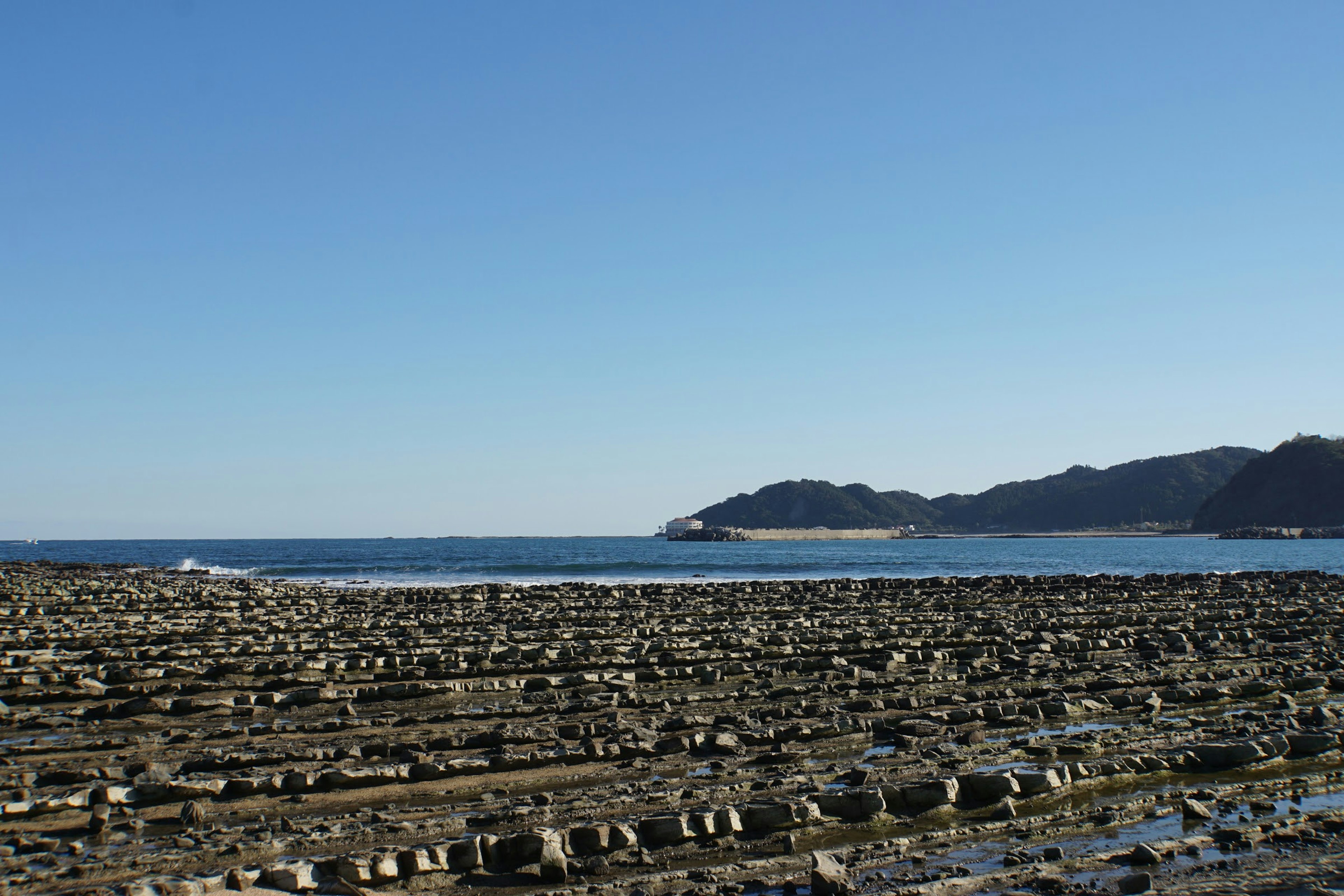 Coastal rocky landscape under a clear blue sky