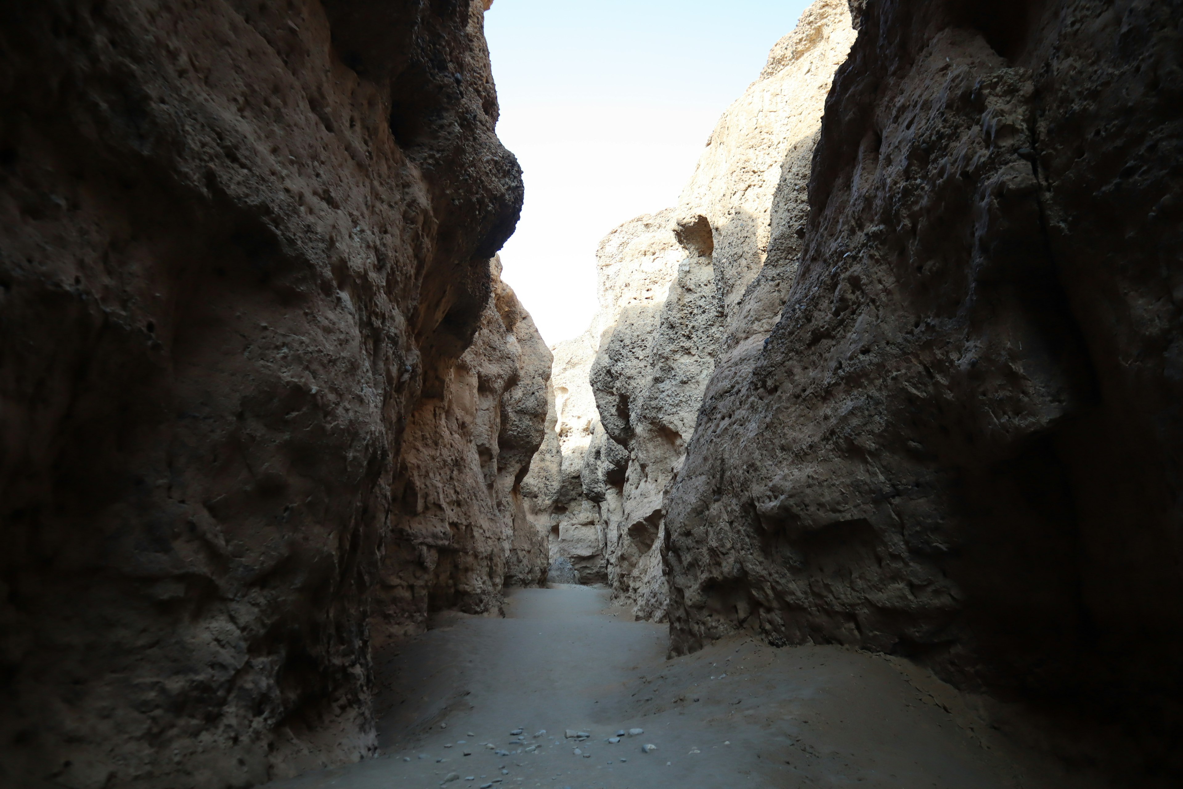 Blick auf eine enge Schlucht mit hohen Felswänden und einem Weg davor