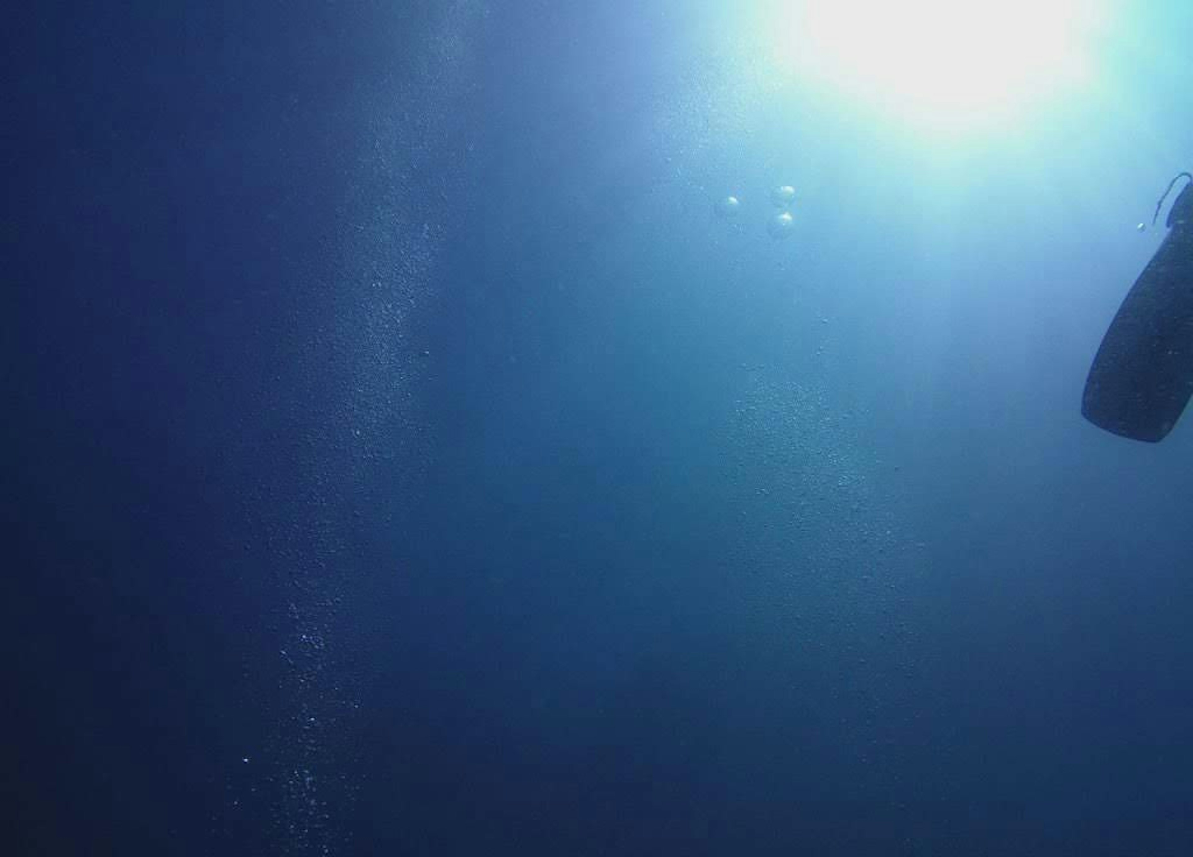 Underwater scene showing deep blue water and light reflections