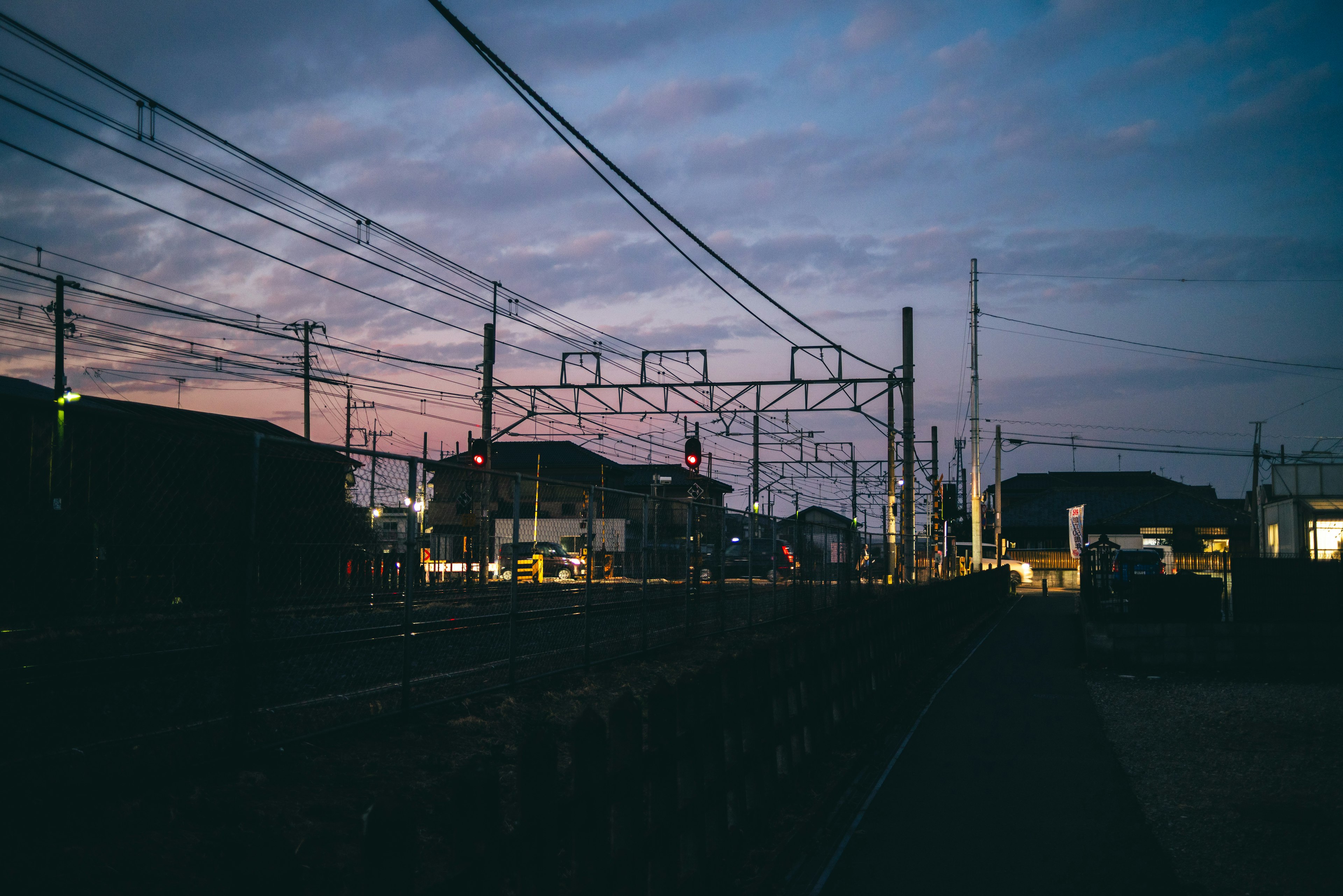 Twilight scene of a train station with railway tracks and signal lights